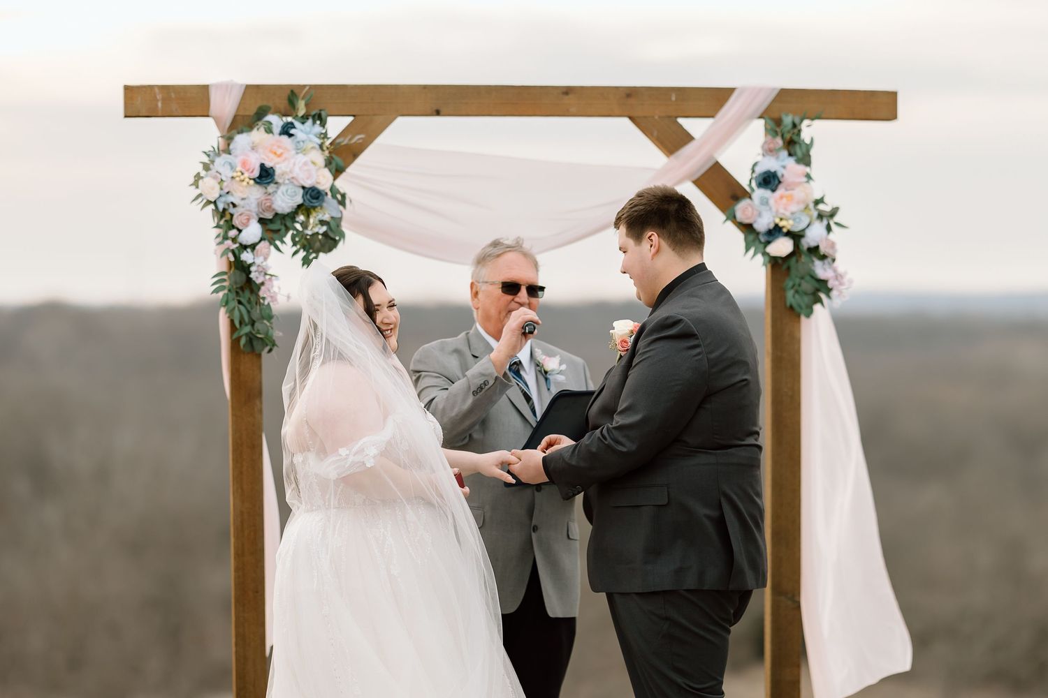 A couple shares an intimate first look moment at their outdoor wedding ceremony with mountains in the background.