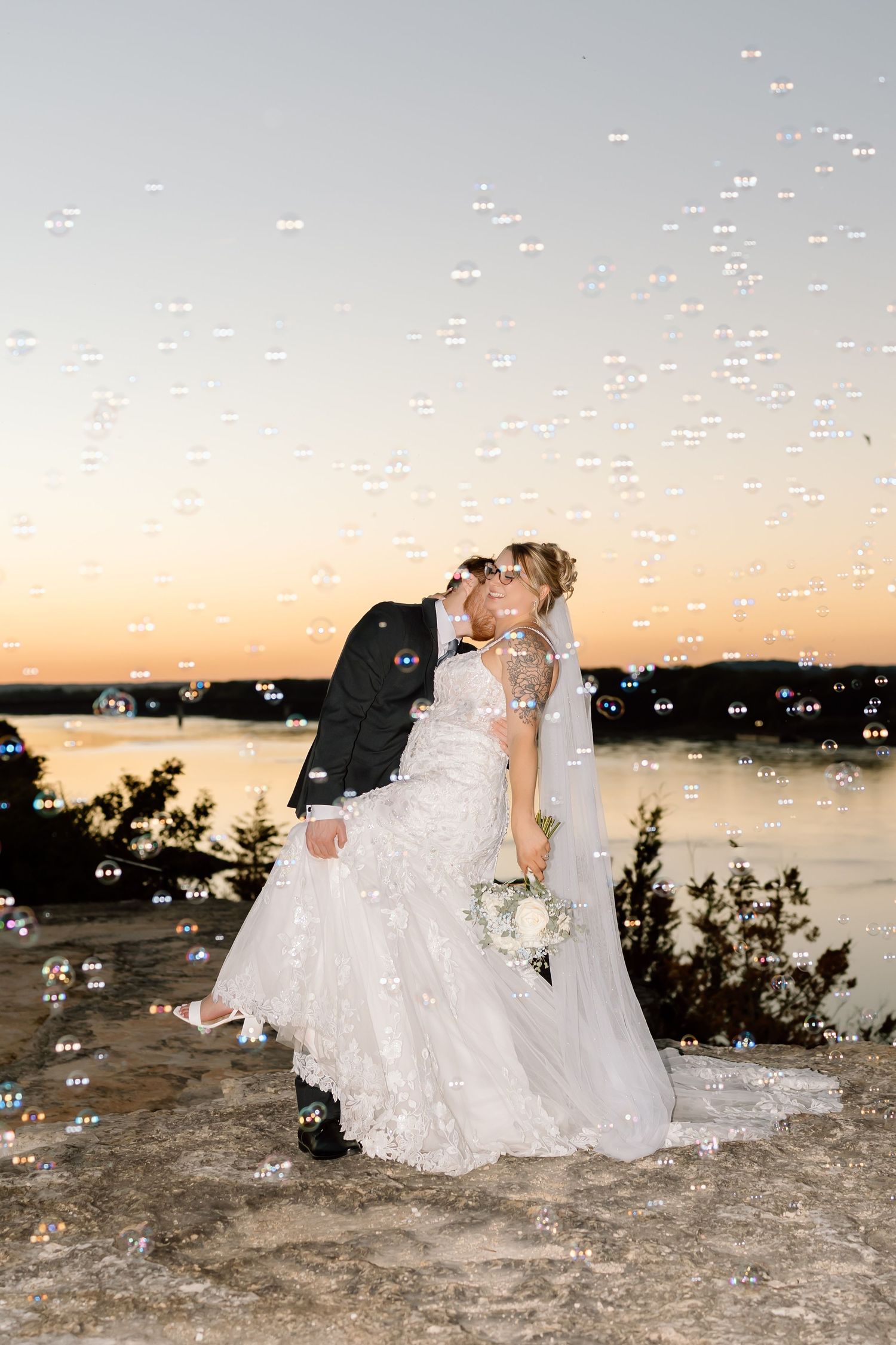 A romantic sunset wedding photo sequence shows a couple in white embracing on rocky terrain by the water.
