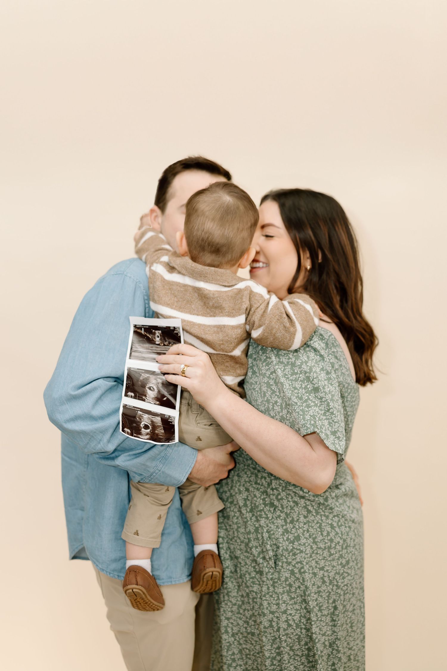 A couple shares a romantic moment while holding an ultrasound photo in a series of progressive shots.