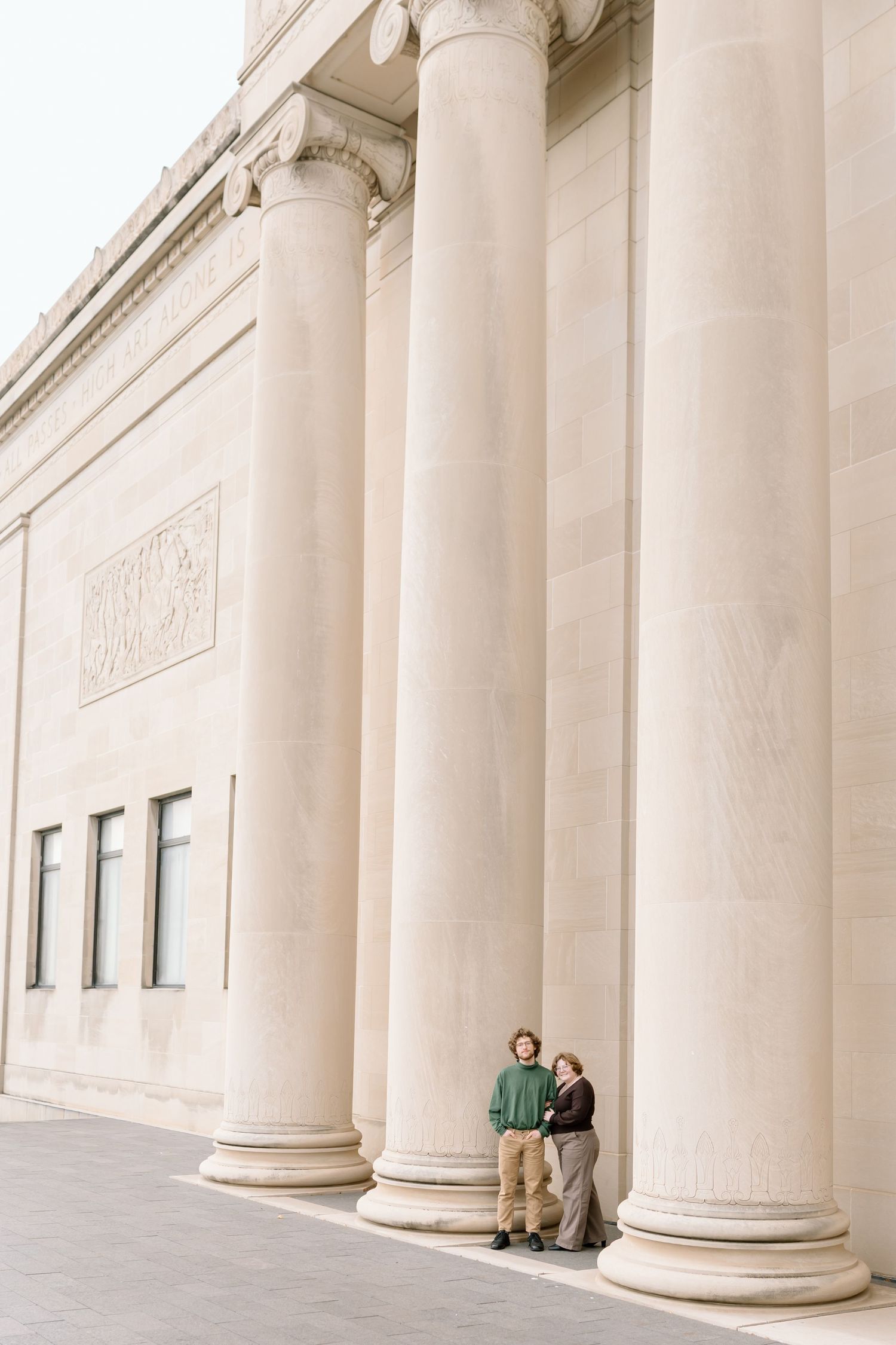 Exterior view of classical building with white stone columns creating dramatic shadows.