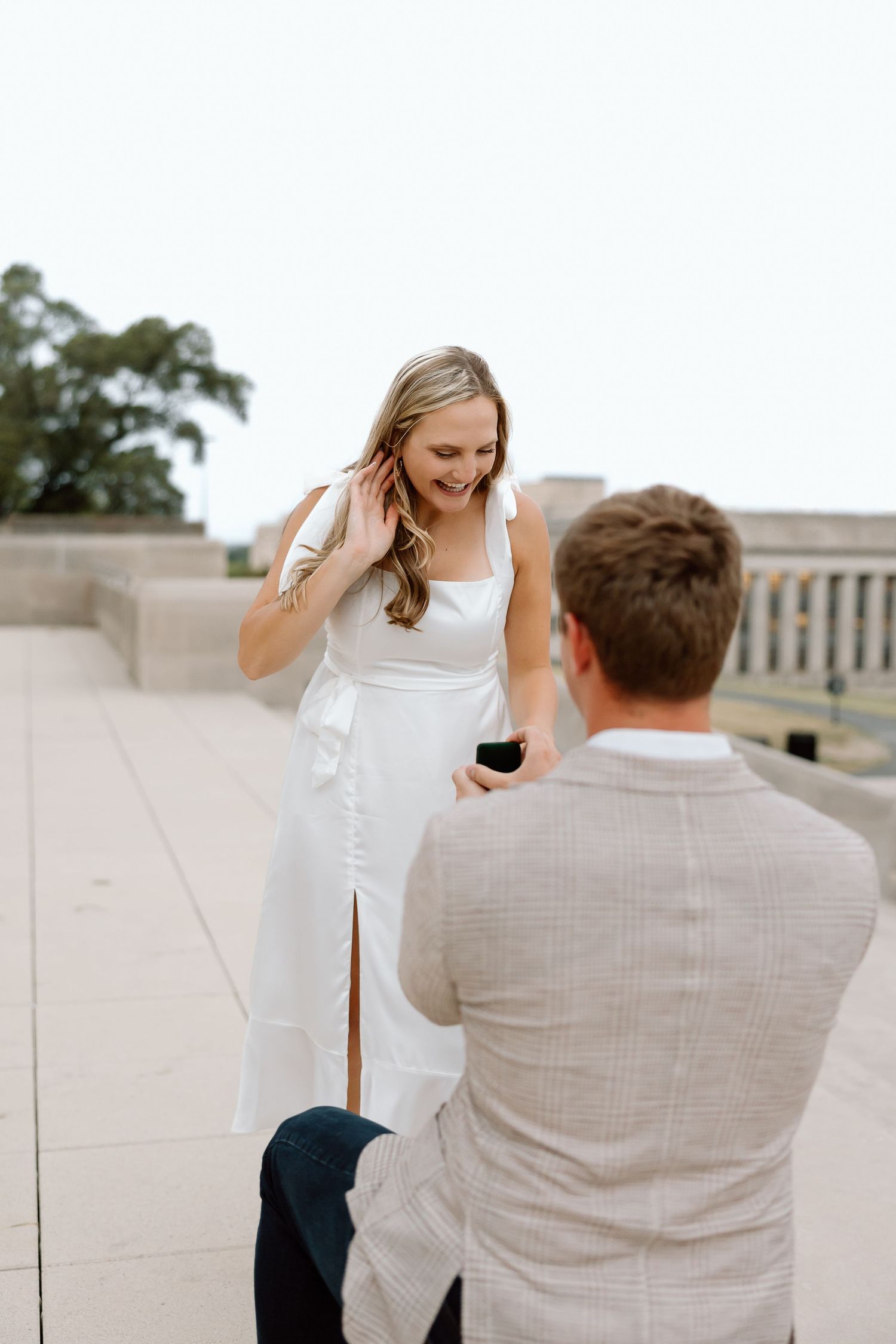 A couple shares a joyful moment during an outdoor photo session on a rooftop terrace.