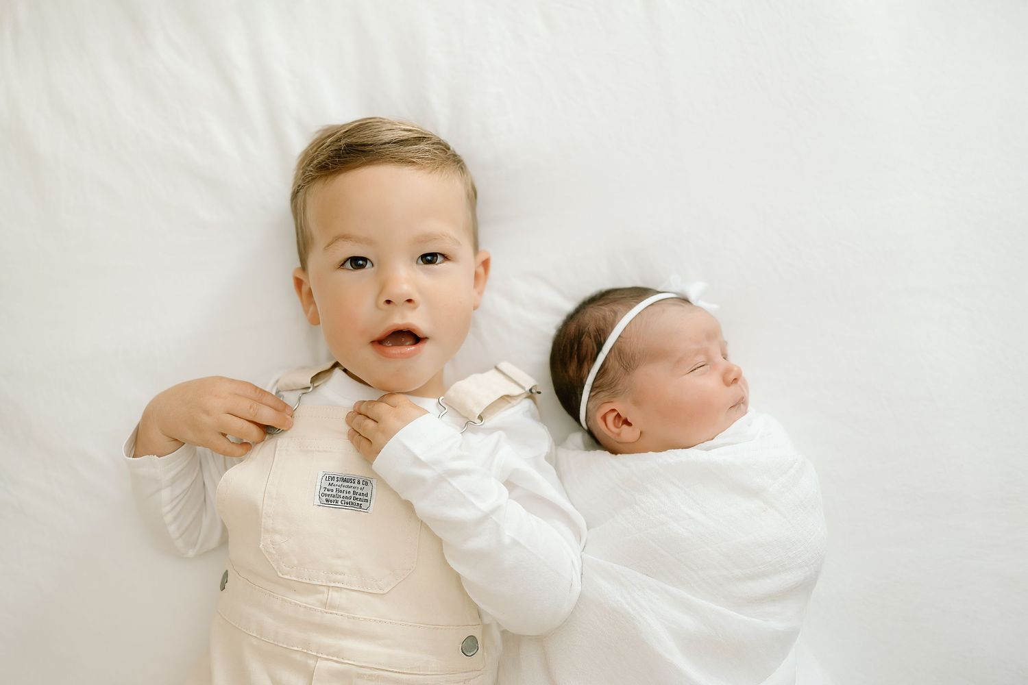 A series of six white-toned baby portraits showing different poses and expressions against a light background.