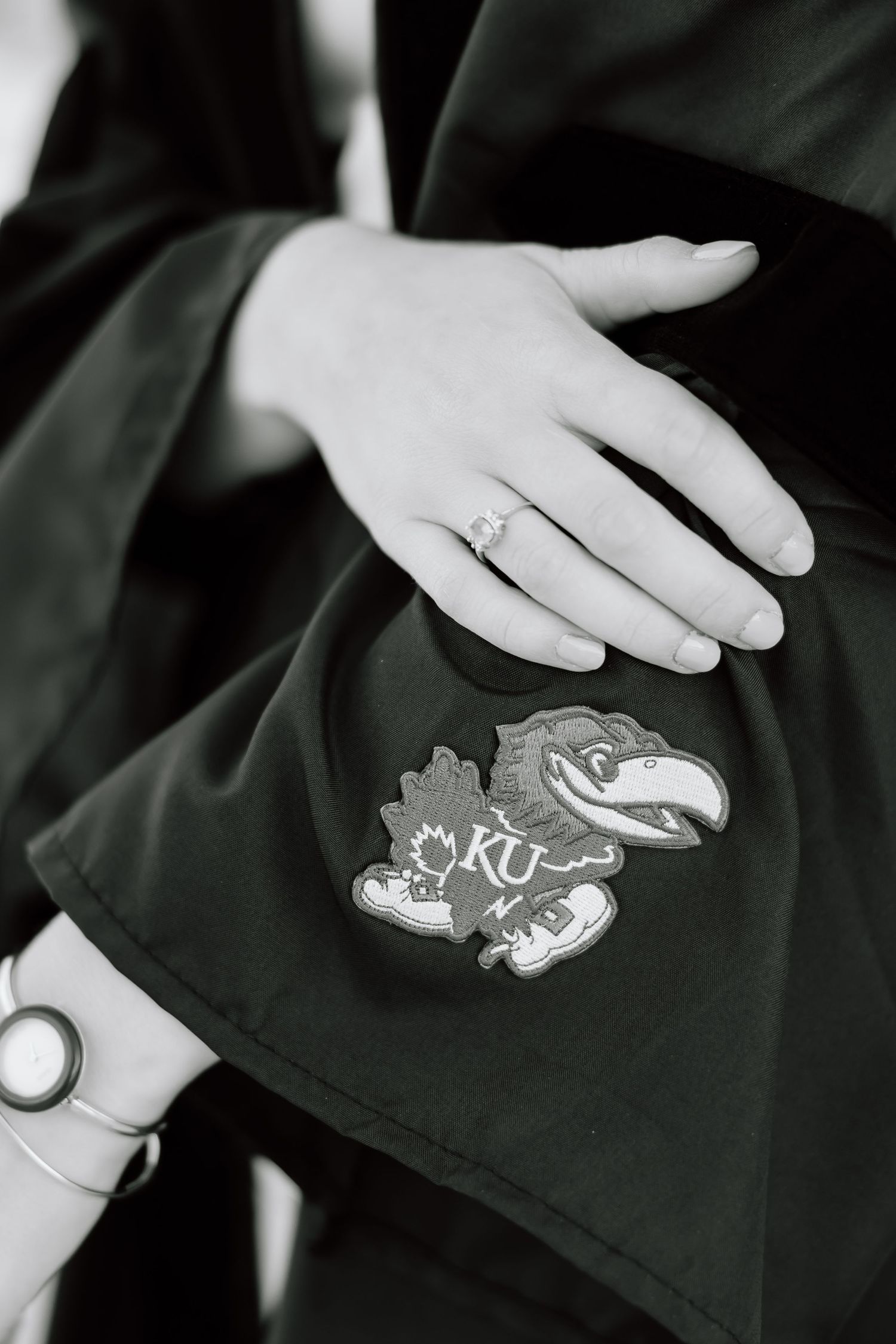 A series of black and white images showing hands holding and displaying embroidered patches or emblems on fabric.