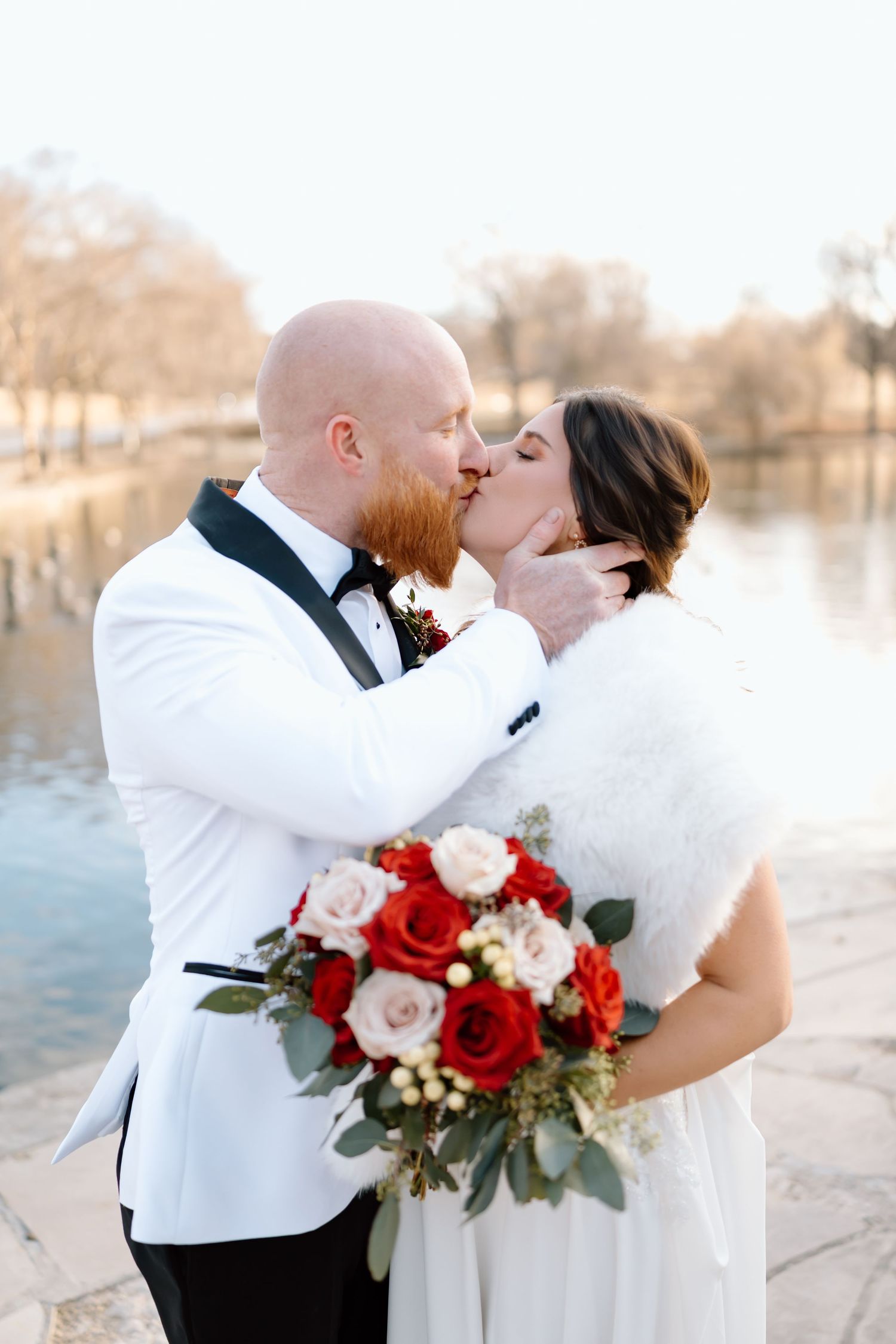 A romantic winter wedding photo collage with red and white roses and elegant white attire by a lake.