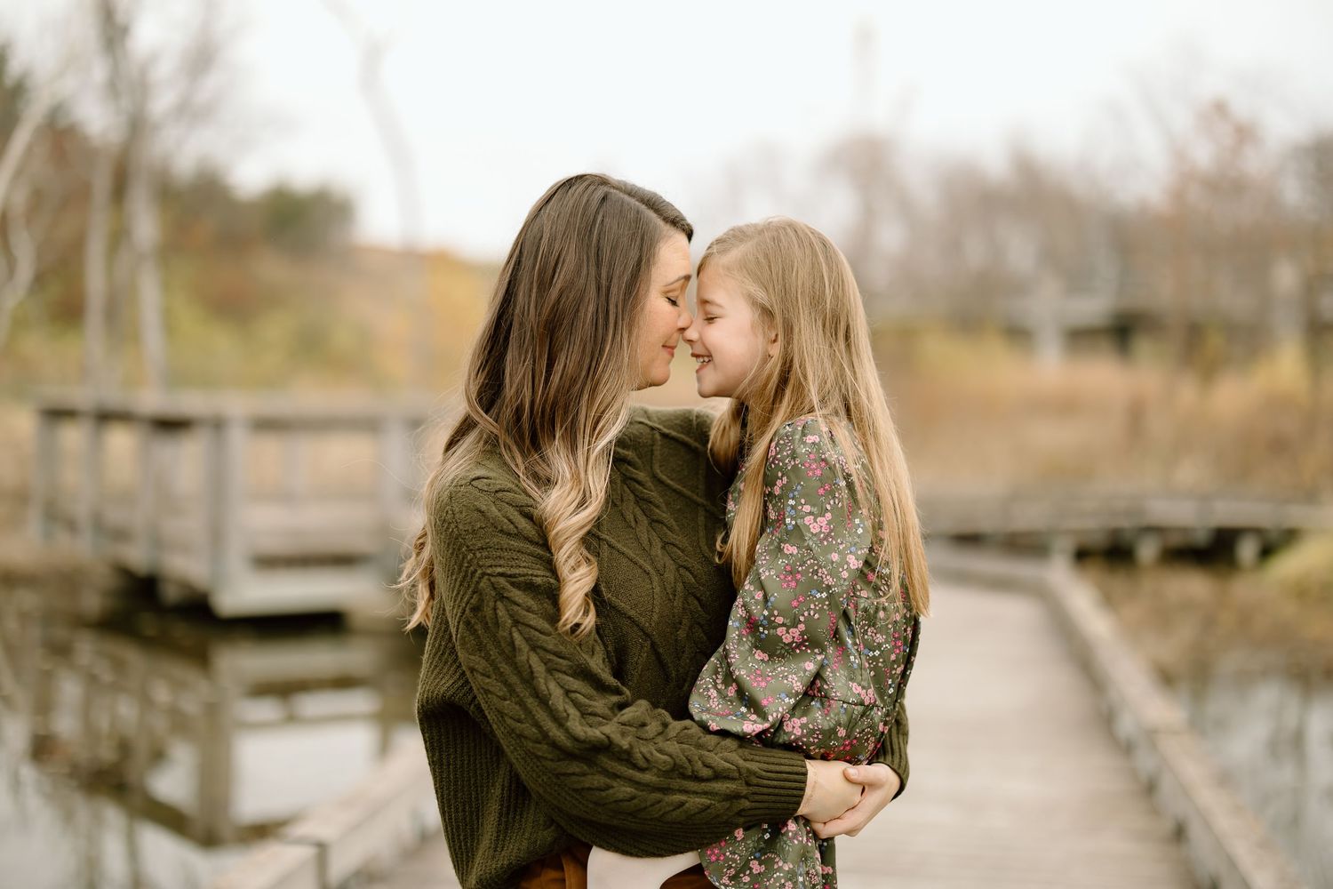 Intimate moment shared between two people on a wooden boardwalk surrounded by fall foliage.
