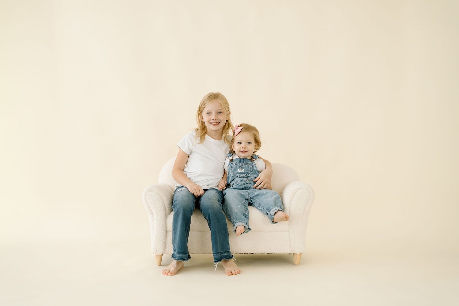 A series of four connected photos showing a parent and child sitting together on a light beige backdrop.
