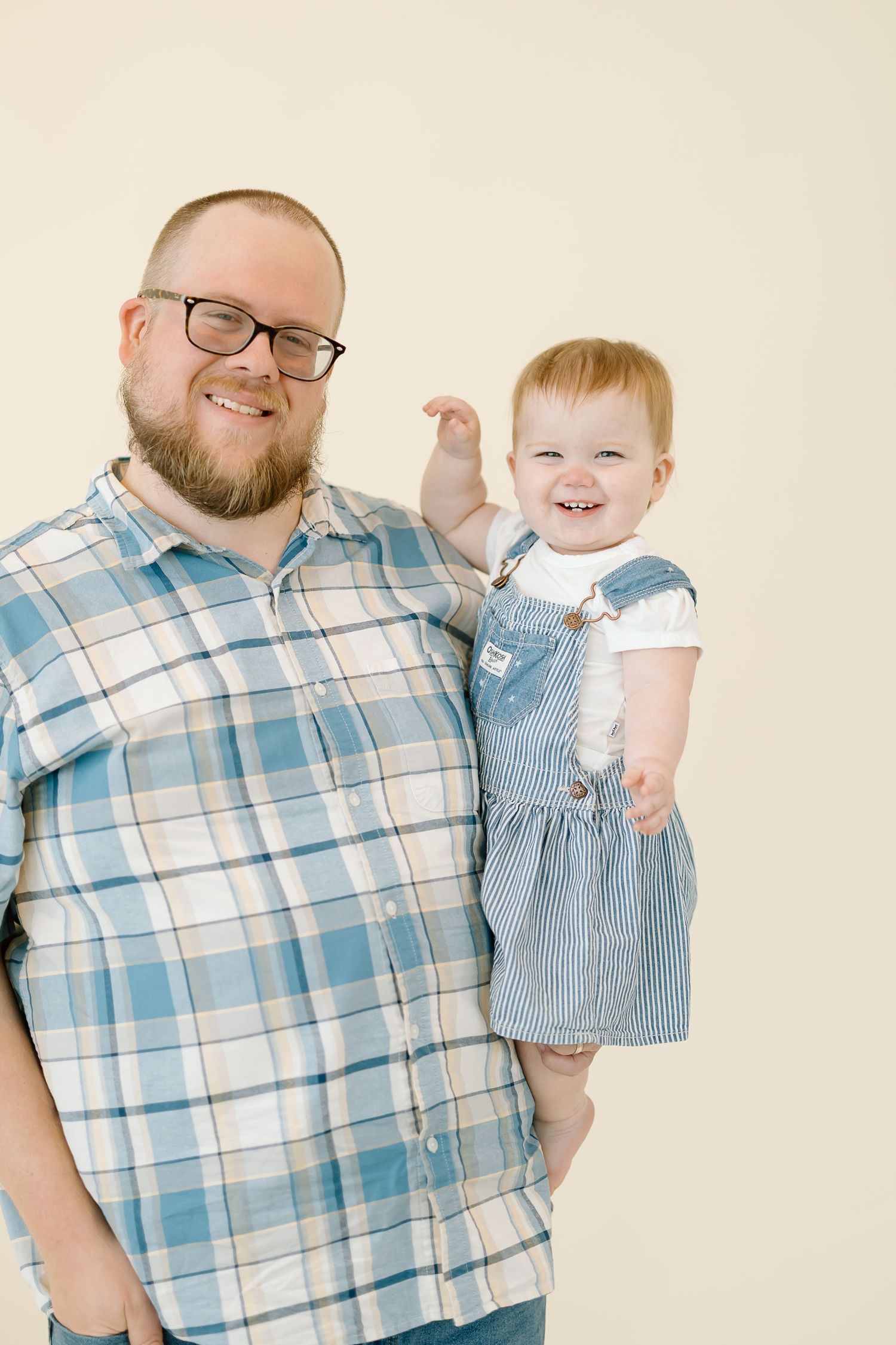 A collection of candid moments between a parent and toddler wearing matching blue plaid and denim in a studio setting.