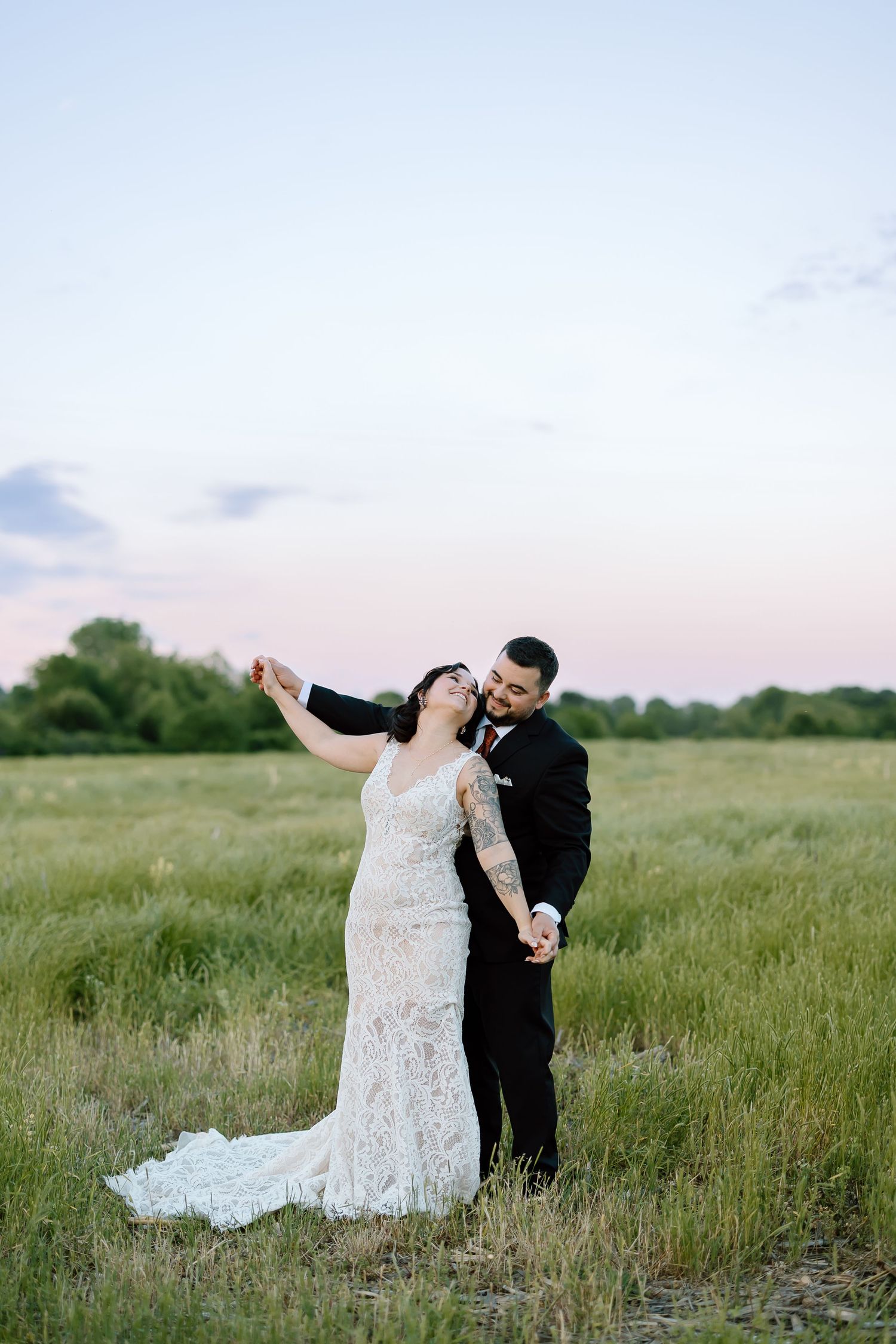 Four sequential images of a couple dancing together joyfully in a lush green meadow on a romantic evening.