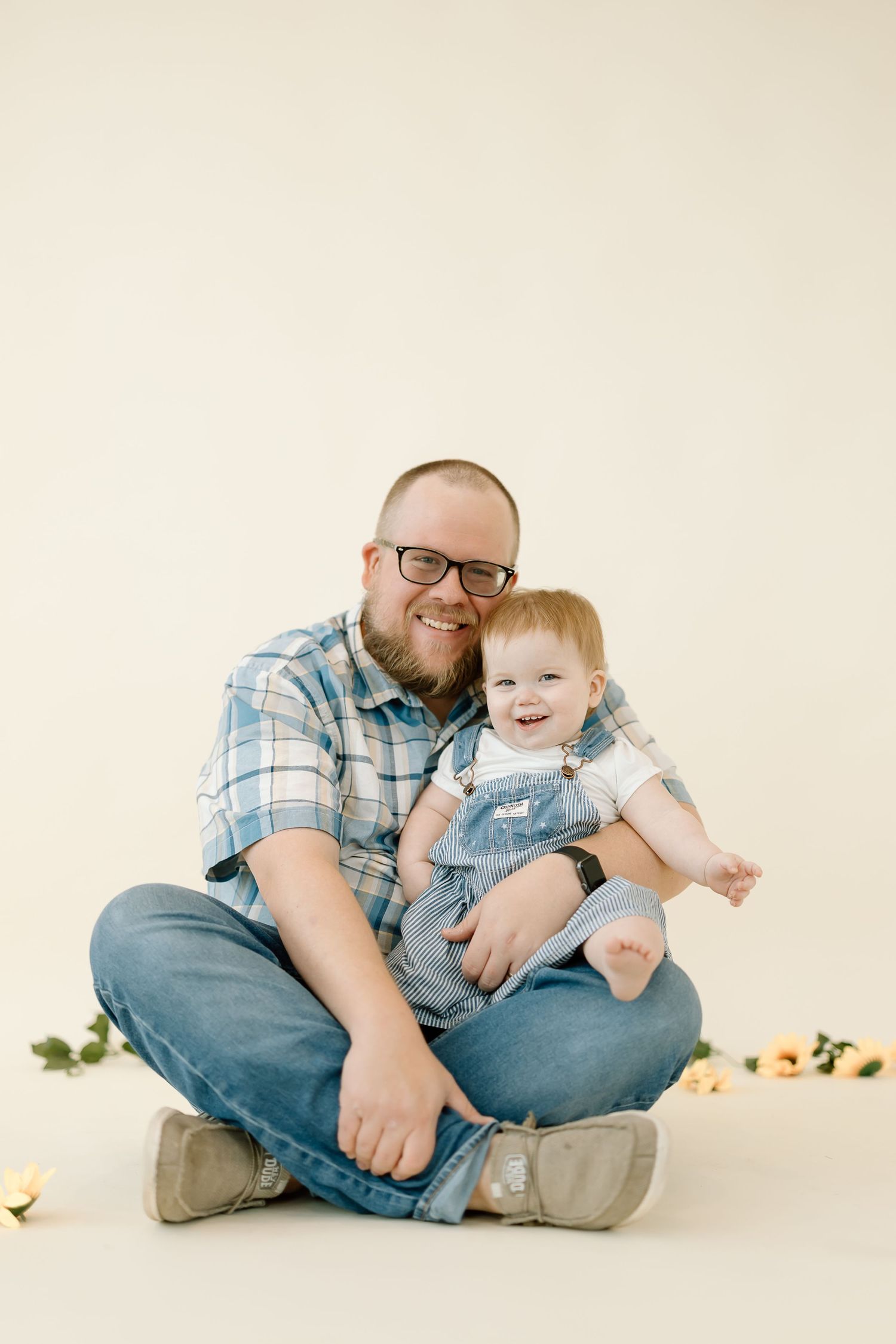 A series of heartwarming photos showing a parent and baby sitting together on a white backdrop with warm lighting.
