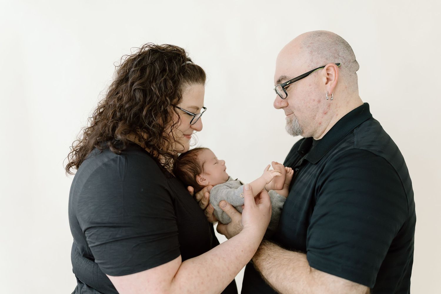 Four sequential black and white photos show a couple in black shirts embracing in emotional moments.