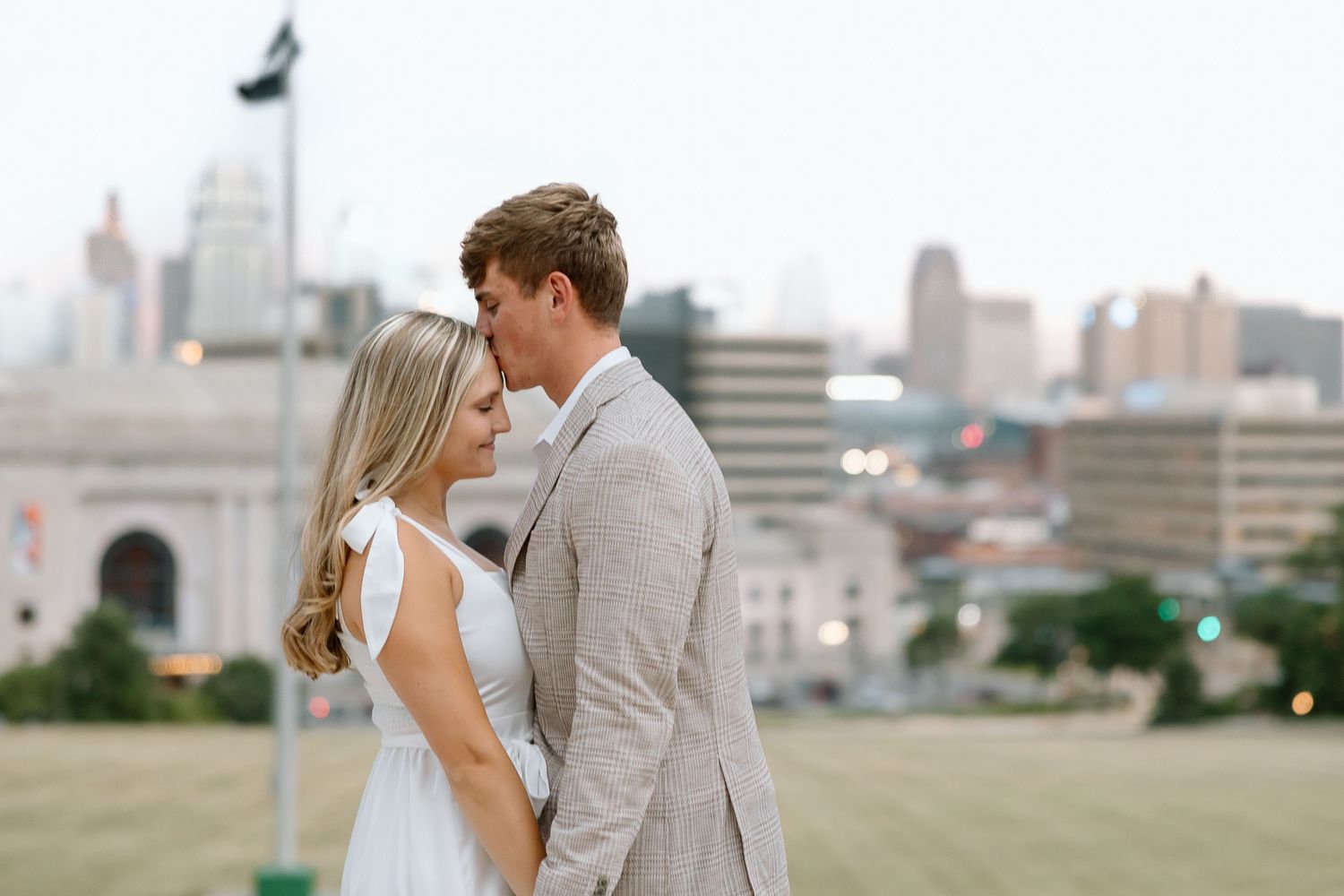 A romantic wedding photoshoot in an urban setting with city buildings in the background.