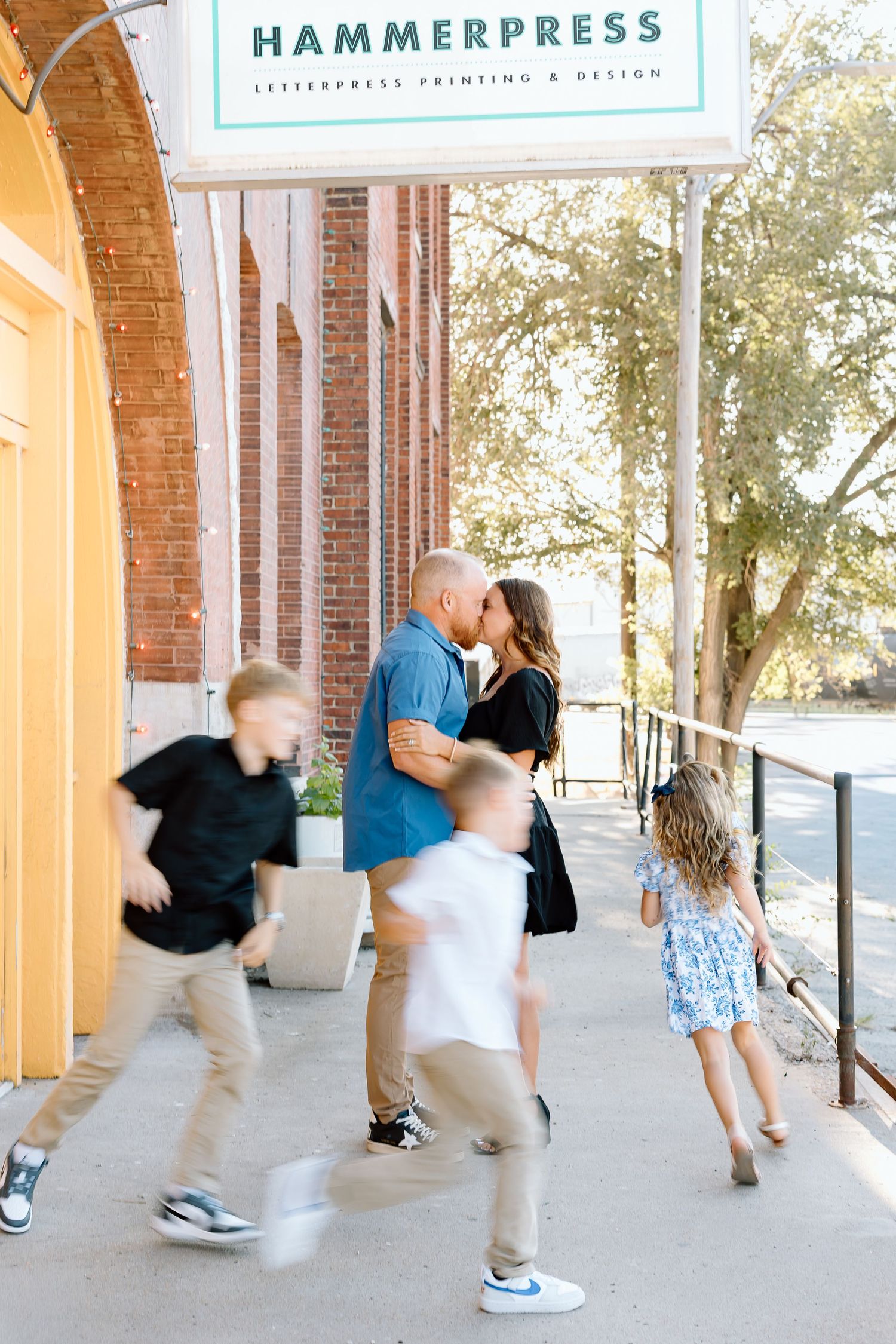 A series of motion-blurred photos showing people dancing and jumping under a brick archway with Hammerpress signage.