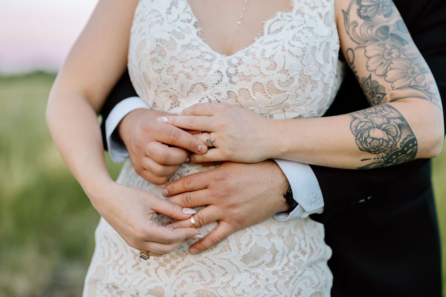 Closeup view of delicate lace details and embroidery on a white wedding dress bodice.