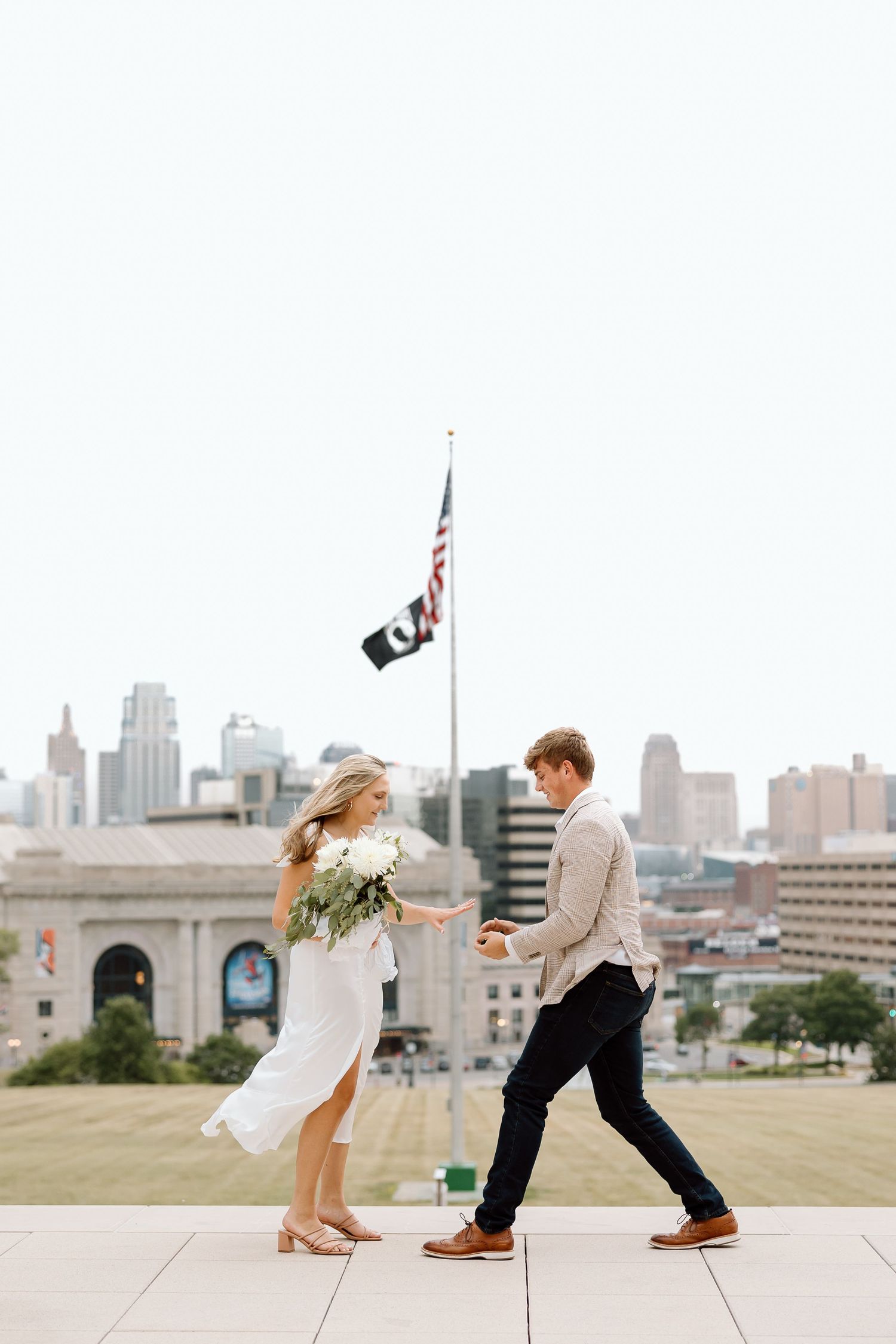 A couple dances playfully in a sequence of four photos with the city skyline in the background.