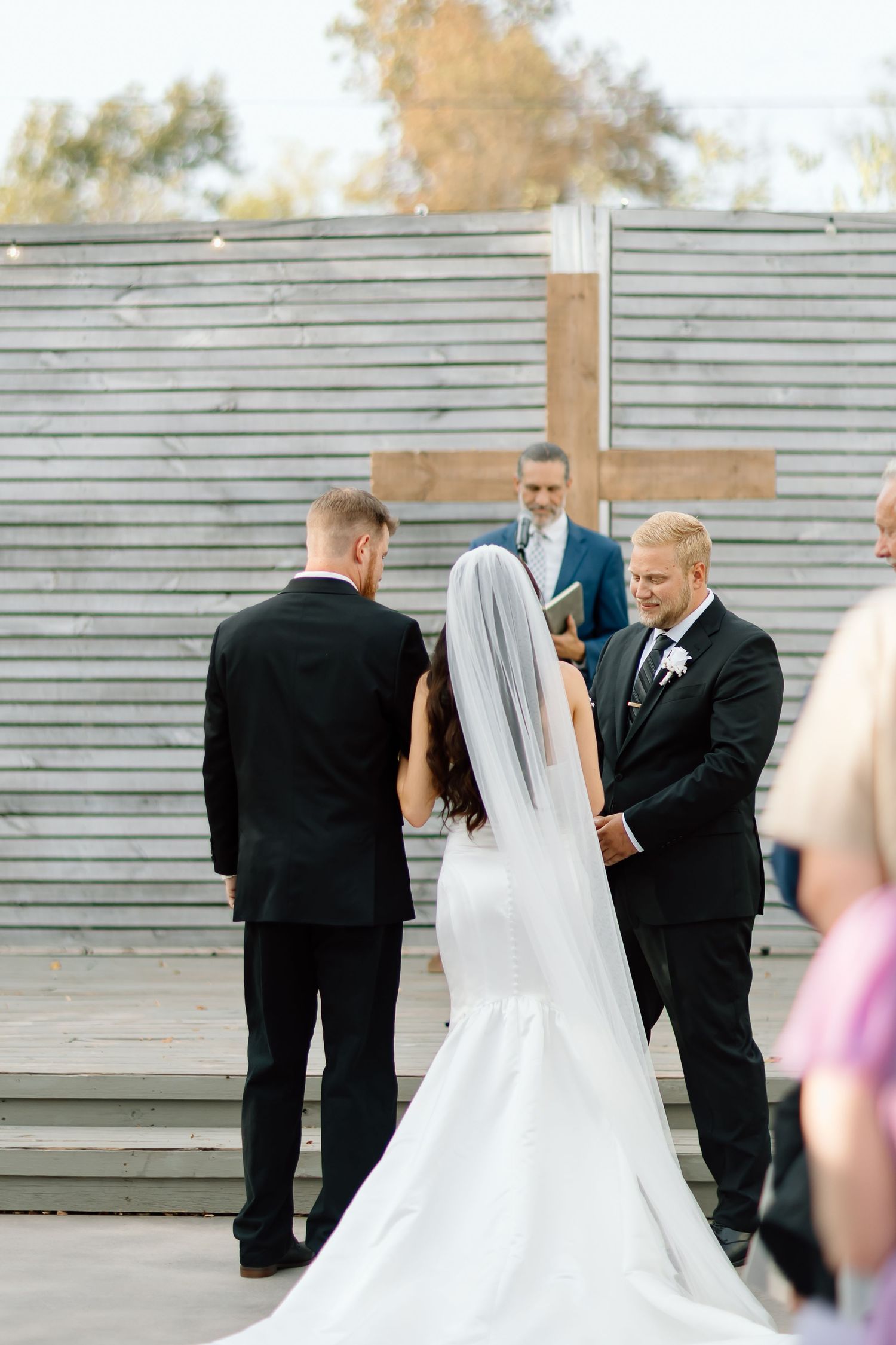 A series of candid wedding photos showing a bride in white dress and groom in black suit embracing outdoors.
