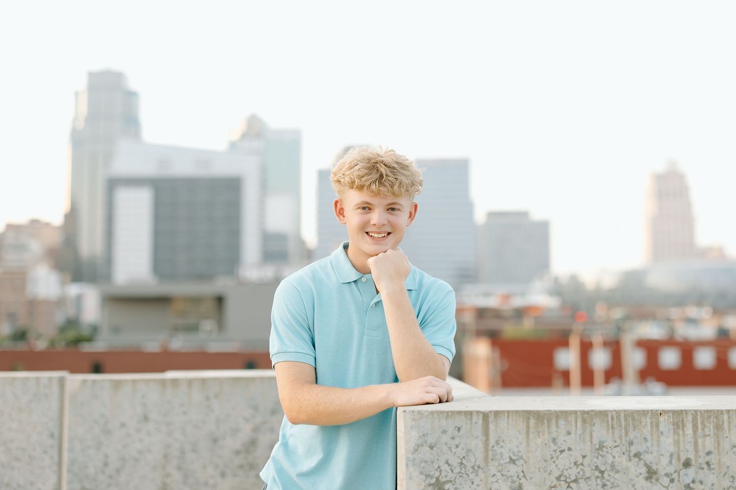 A series of five professional headshots against urban rooftop backgrounds showing someone in light blue attire.