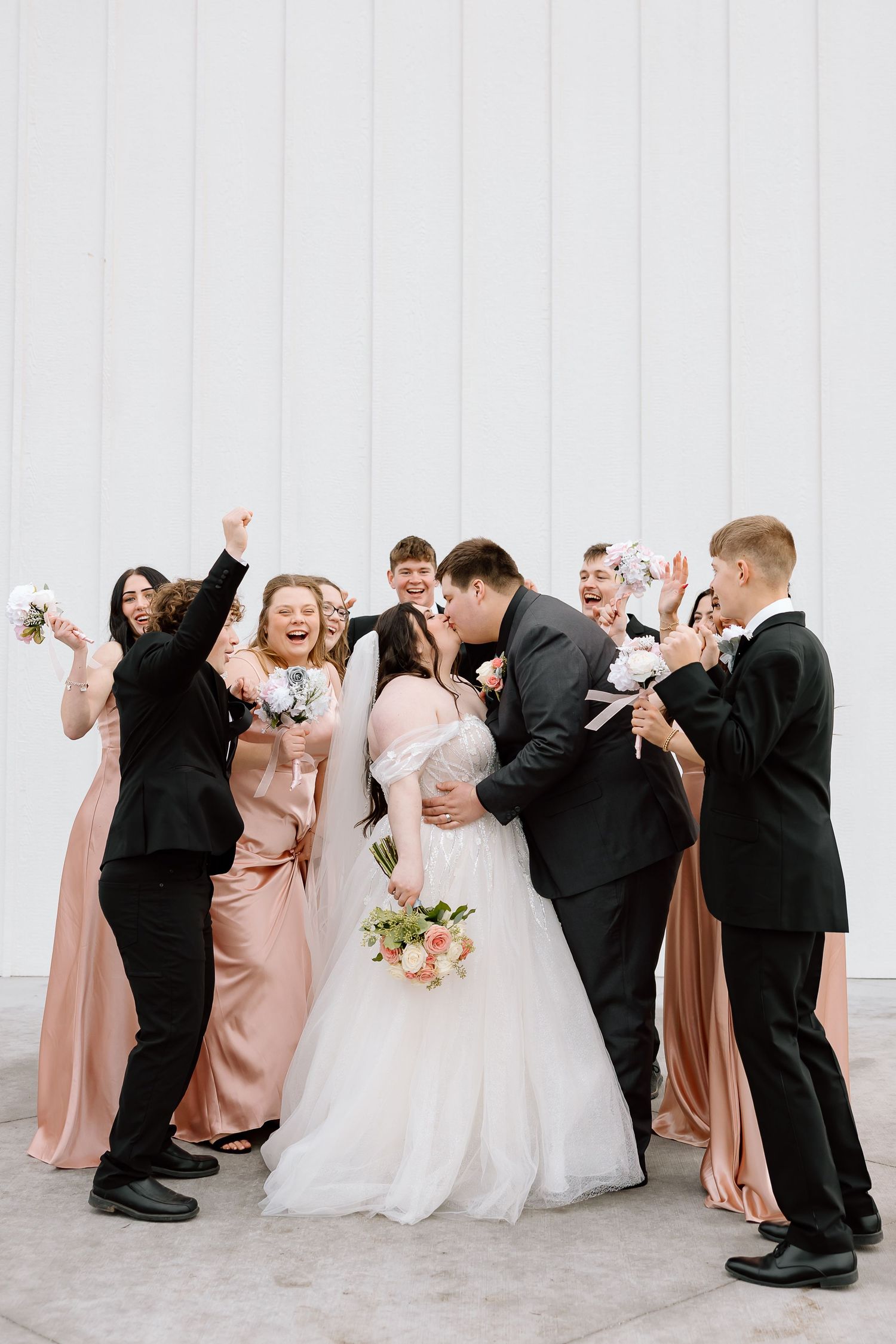 Wedding party in formal attire poses for fun photo sequence showing playful dips and dance moves in blush and black colors.