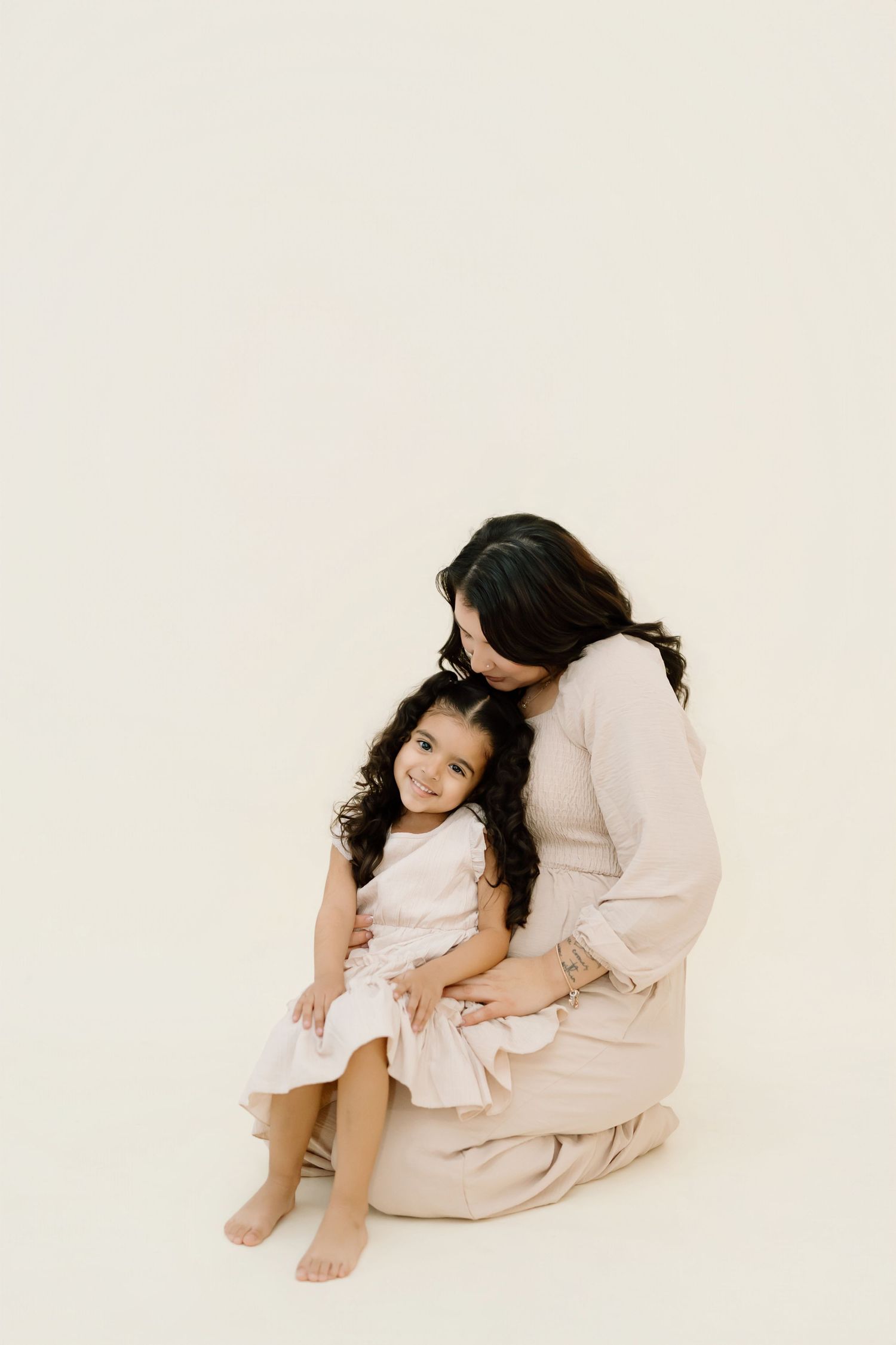 Three sequential photos of a young girl in white dress sitting and posing against light background in studio setting.
