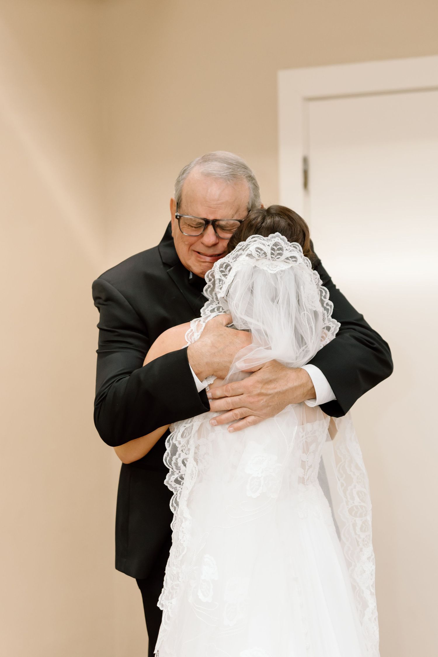 Four sequential photos showing an emotional embrace between two people at what appears to be a wedding ceremony.