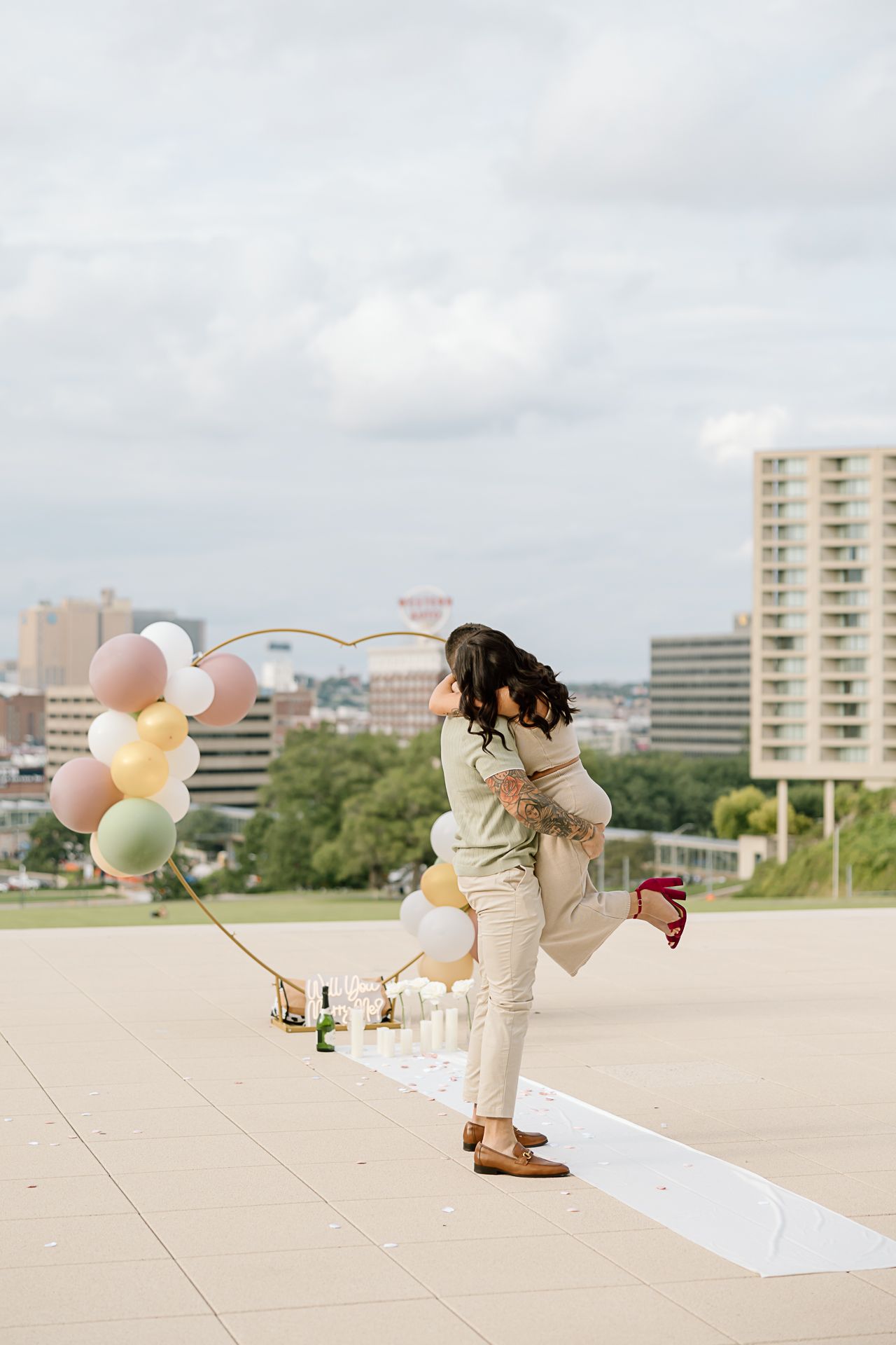 A surprise rooftop proposal moment captured in sequence with decorative balloons and city buildings in background.