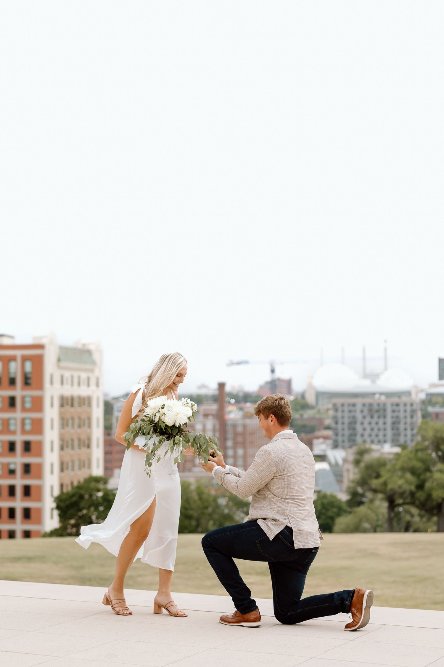 A proposal scene captured in multiple frames showing someone getting down on one knee against an urban backdrop.