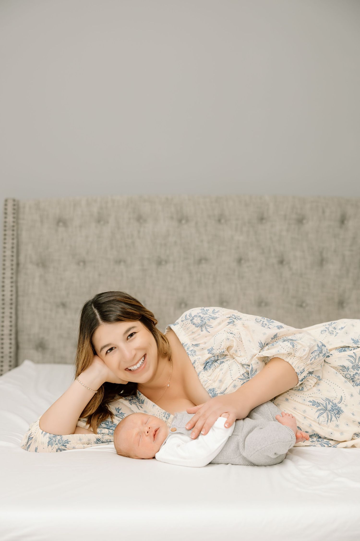 A series of four connected photos showing someone lying down on a white bed with floral bedding in soft, neutral tones.