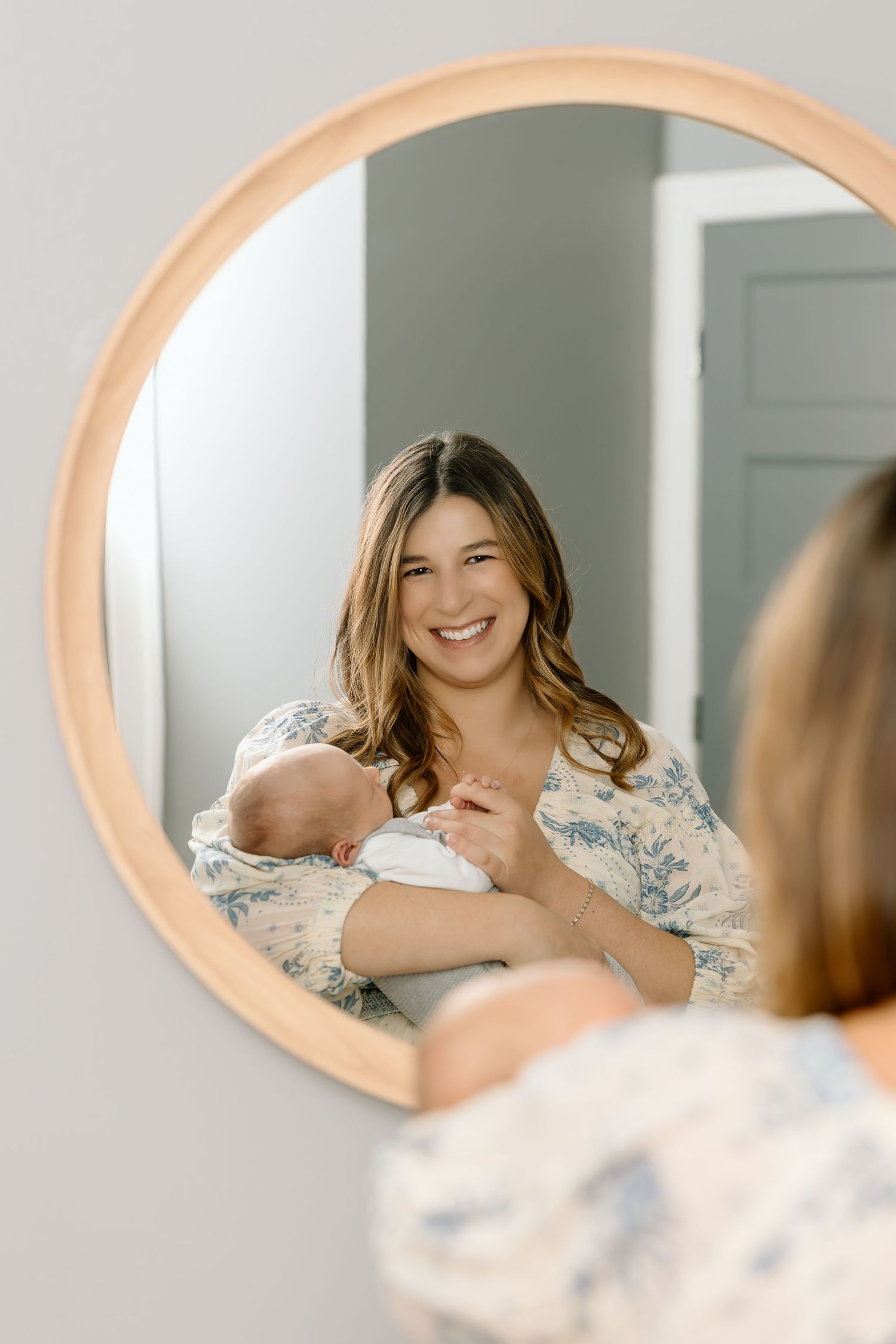 A series of mirror reflections shows someone wearing a floral dress smiling and posing in soft natural lighting.