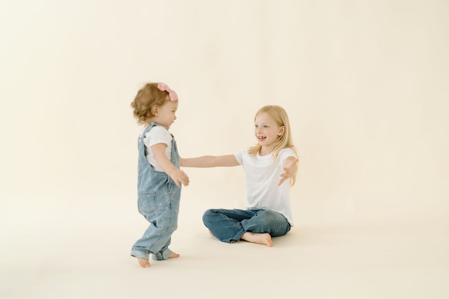 Four connected images showing children in denim overalls playing and interacting on a light beige background.