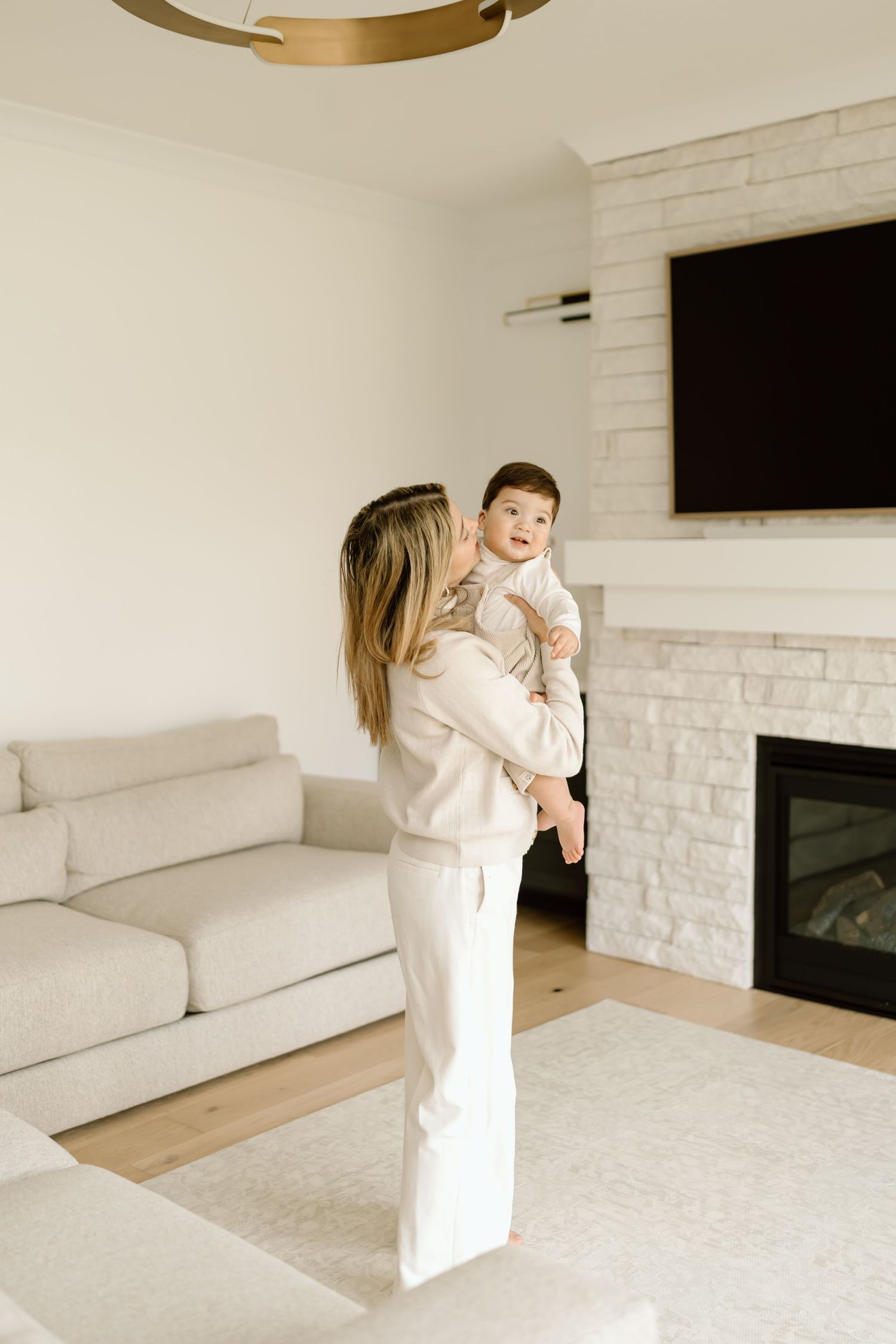A sequence of joyful moments in a bright white modern living room with a baby and parent playing together.