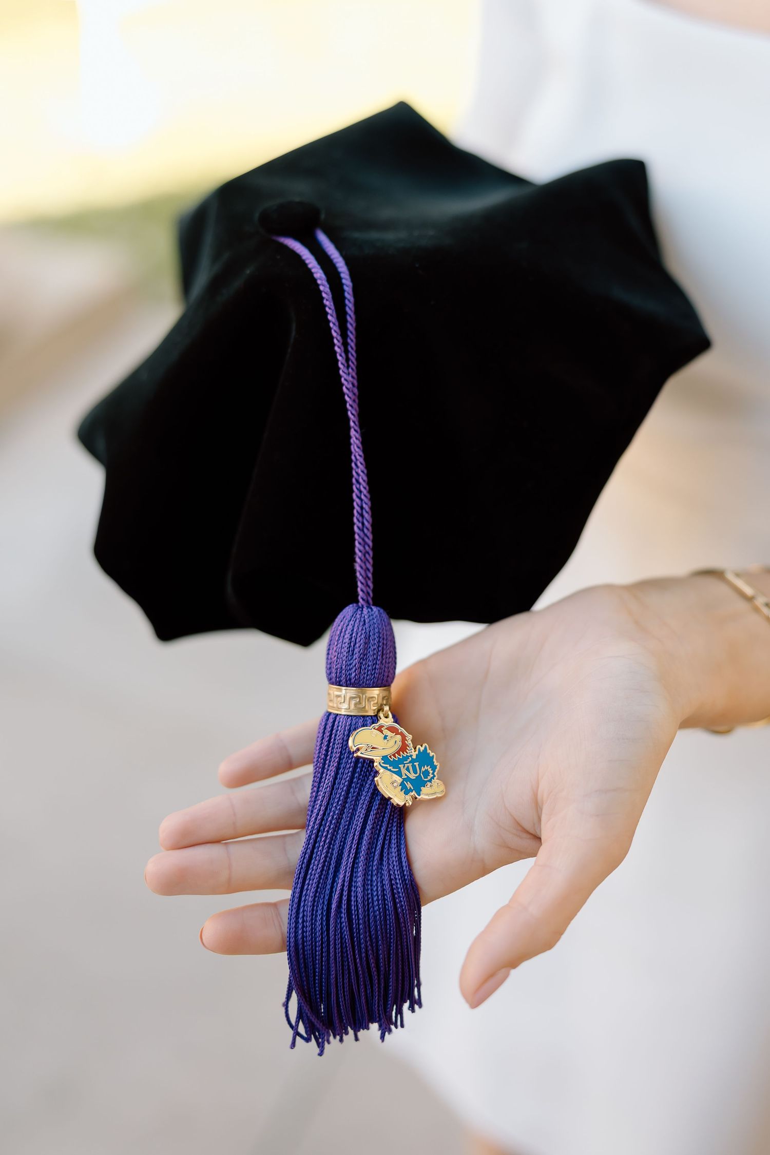 A close-up sequence showing a purple graduation tassel being held against a blurred background.