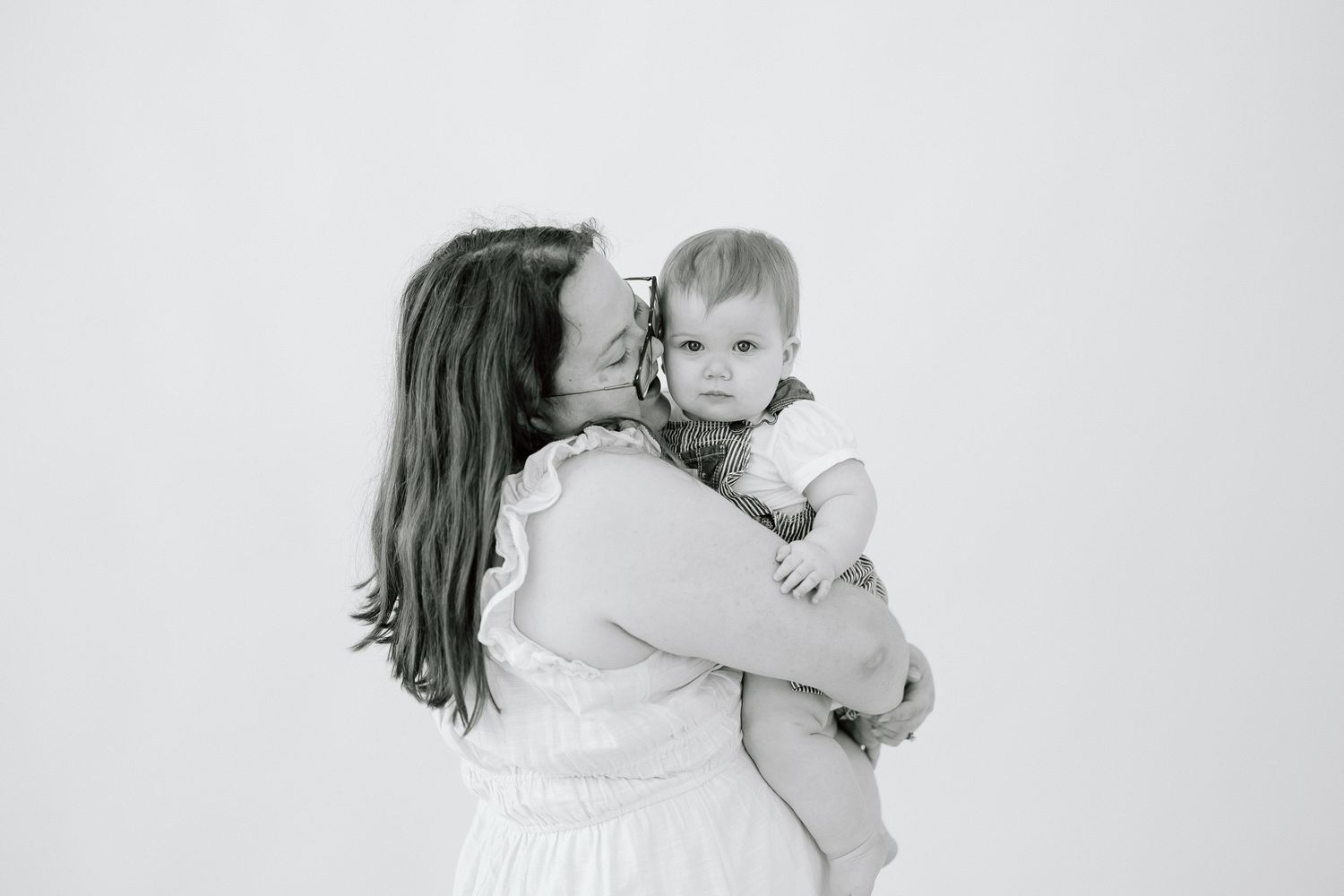 A series of black and white photographs showing tender moments between a mother and child against a white background.