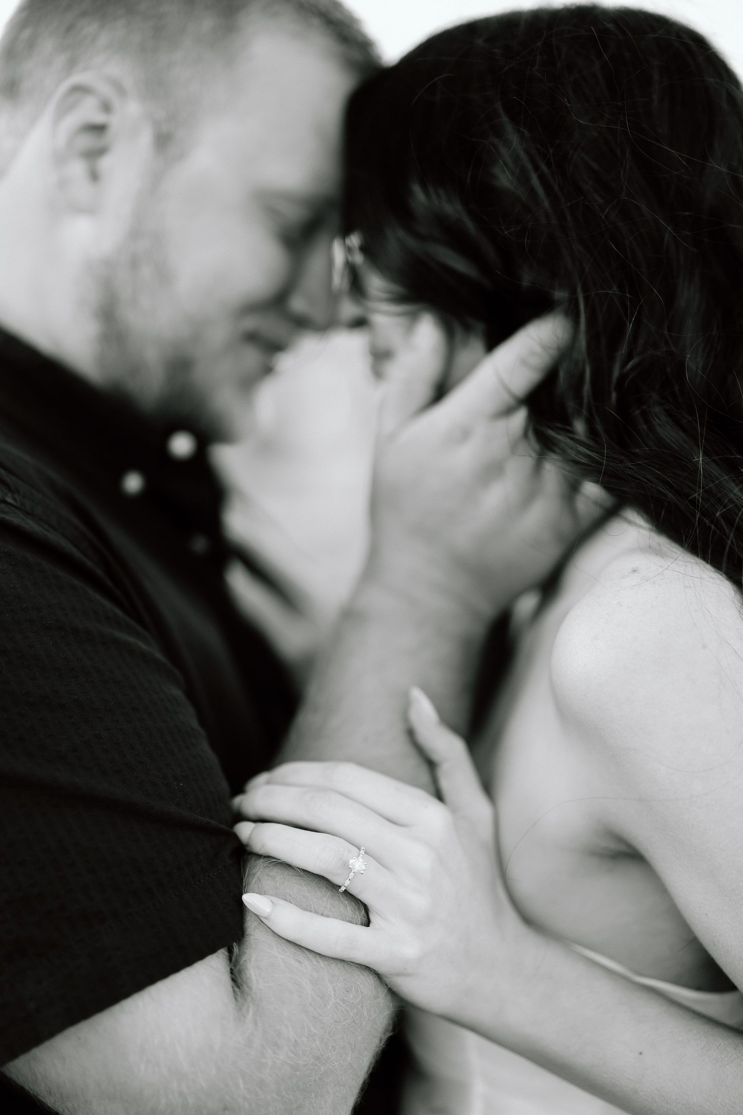 A romantic black and white photo series showing tender intimate moments between a couple in close embrace.
