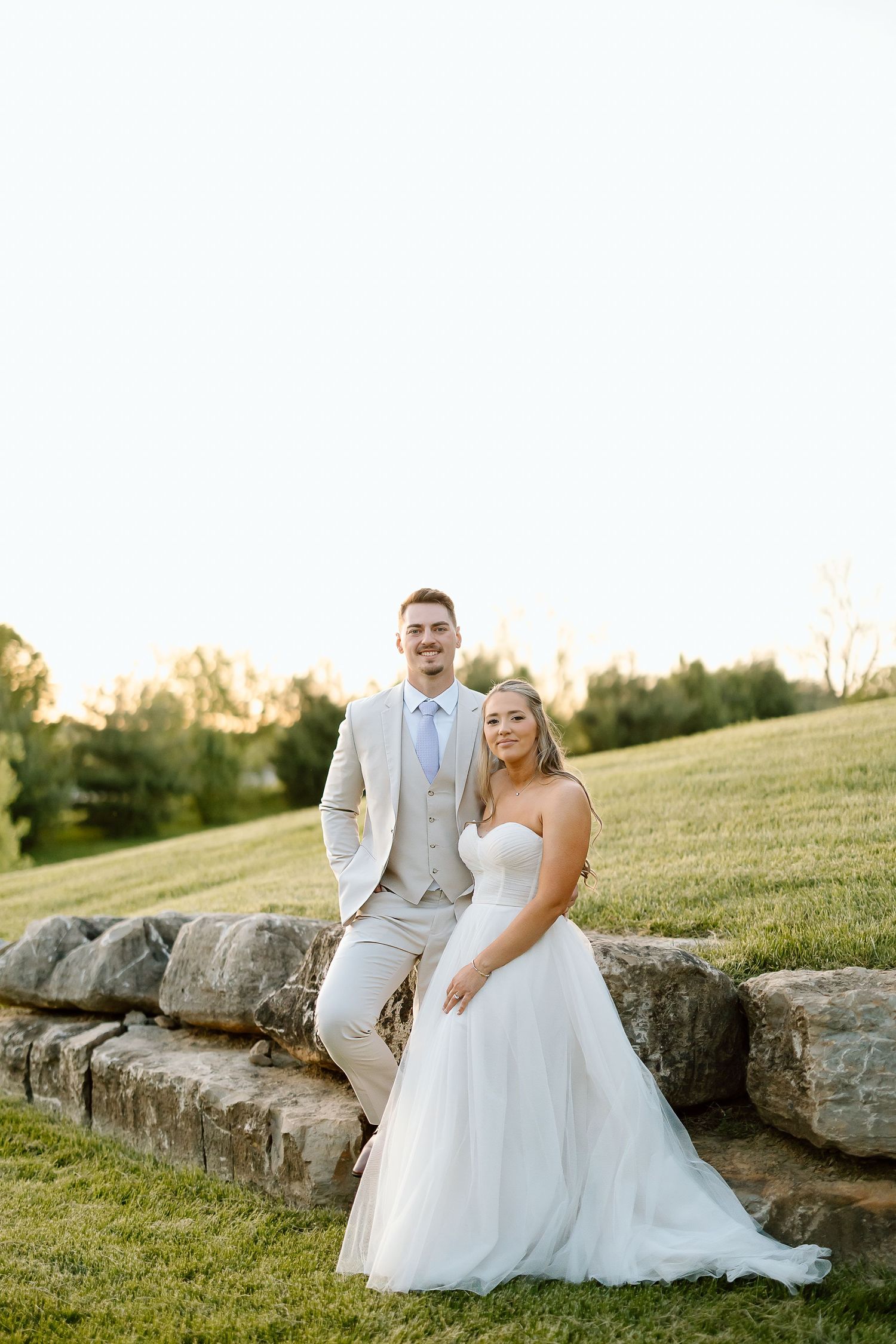 Bride and groom pose for portraits on stone steps in an outdoor setting.