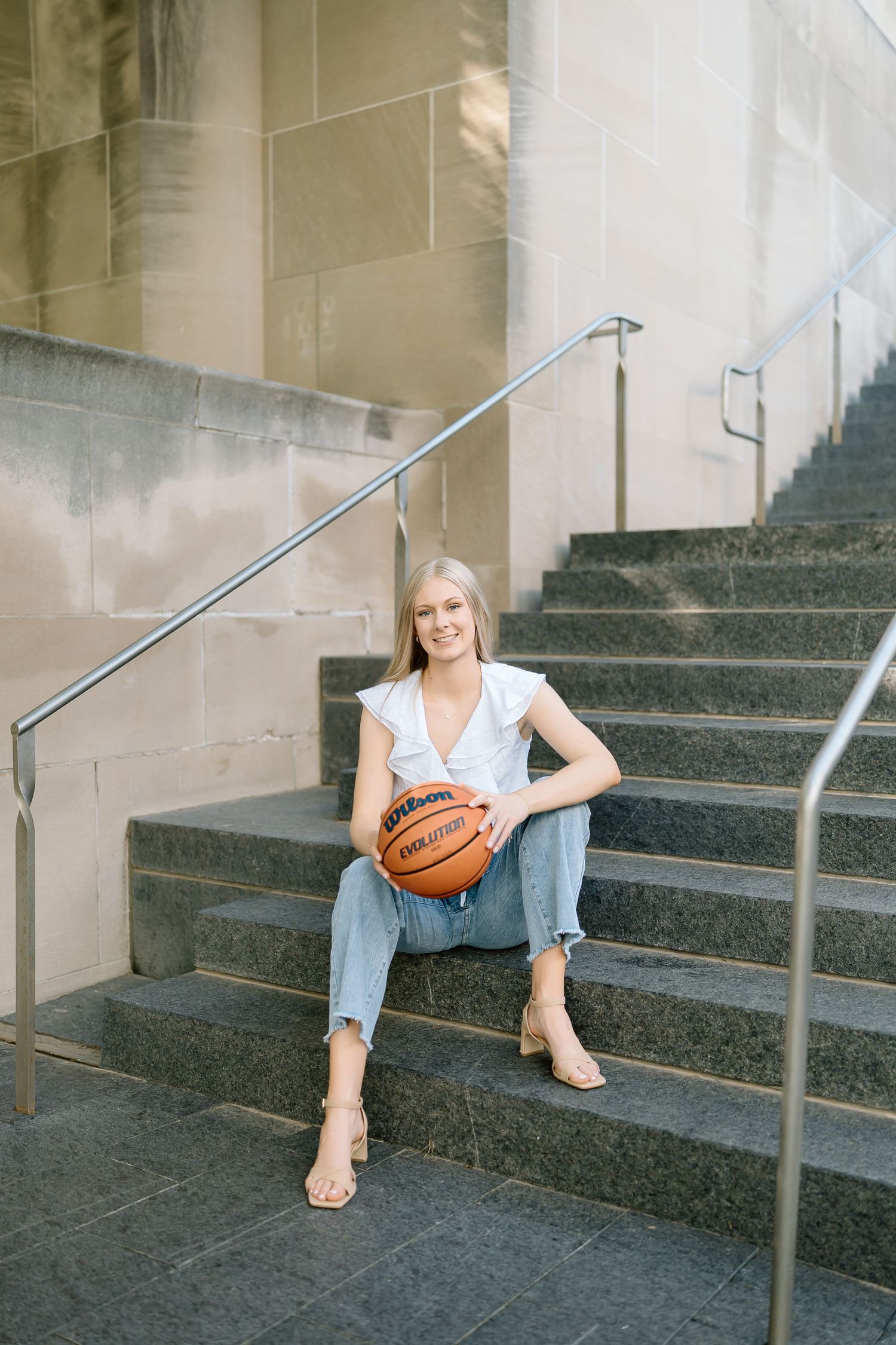 A person in casual attire sits on stone steps with a basketball, shown in a series of four similar poses.