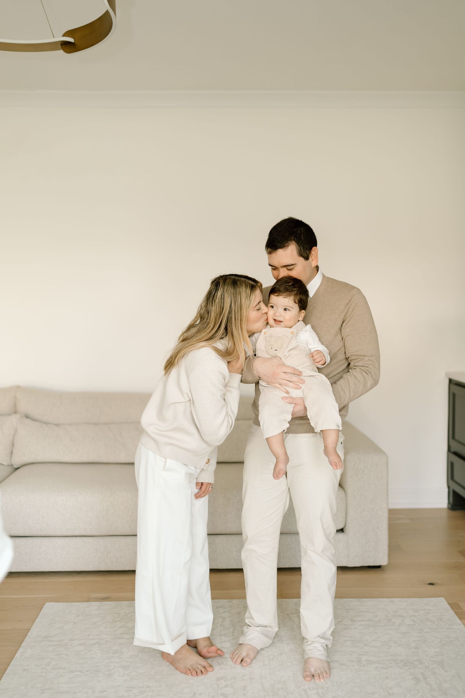 A tender family moment captured in a series of minimalist photographs with soft neutral tones and white decor.
