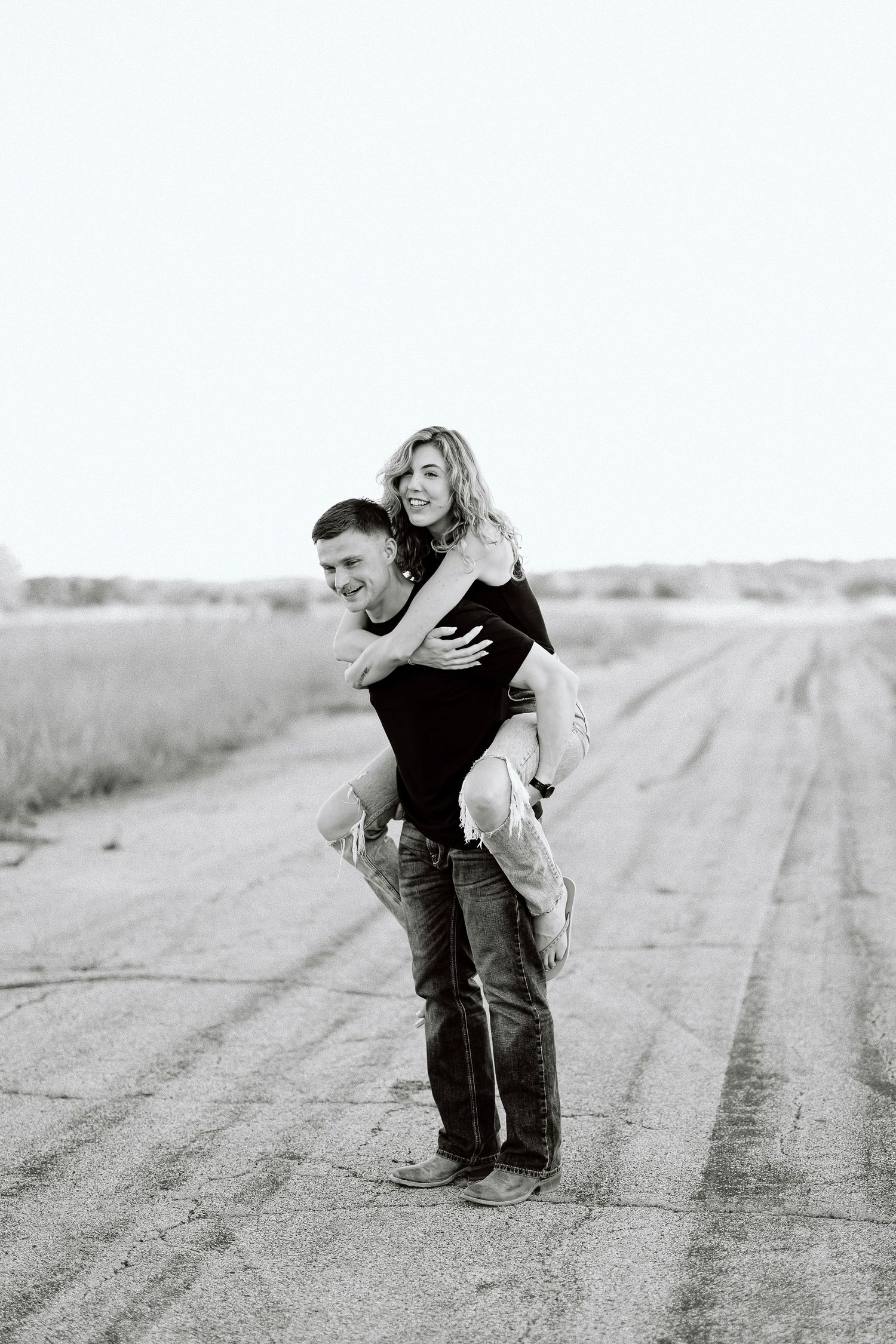 A black and white photo sequence shows someone playing with a cat in a rural dirt field.