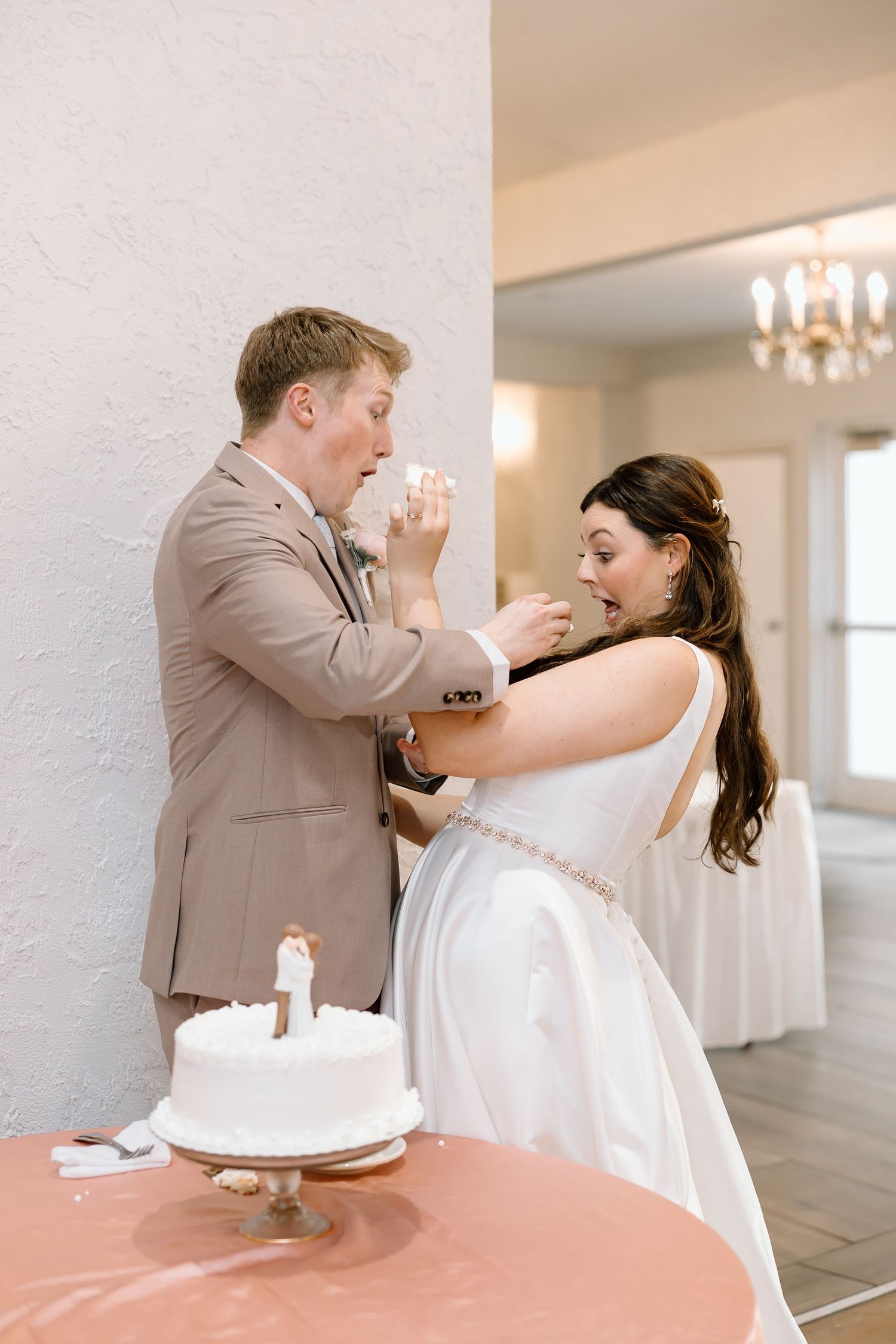A couple dancing and dipping in a bright indoor venue with chandeliers.