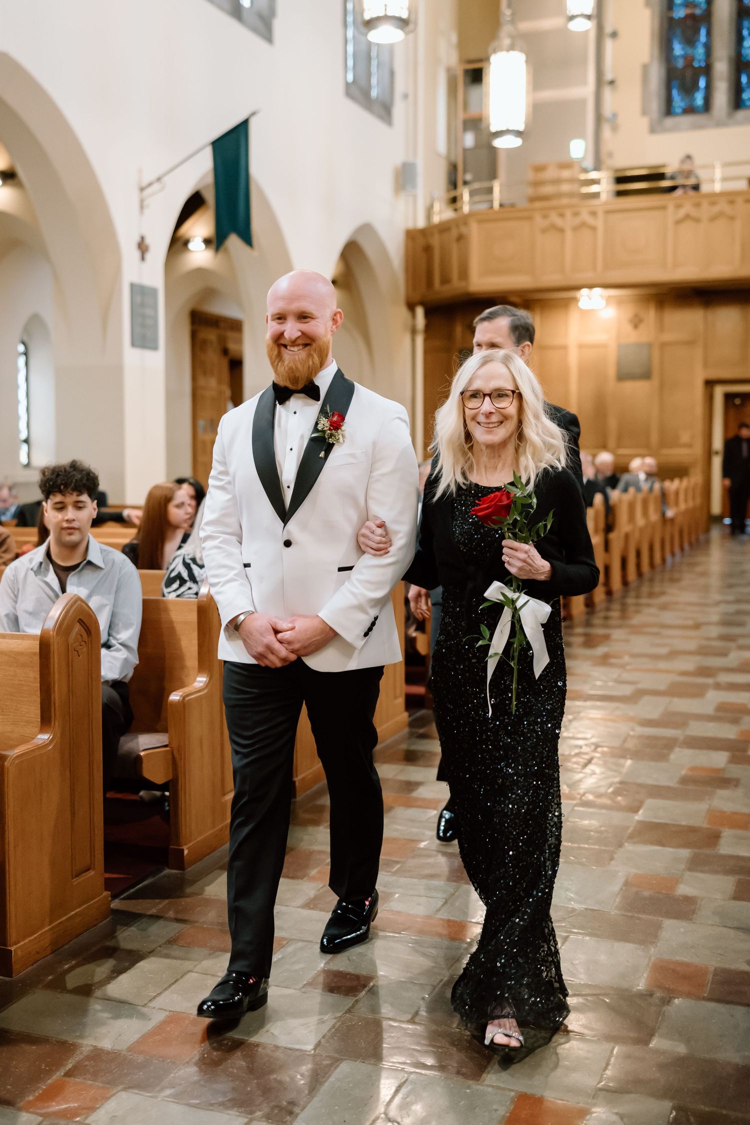 Four candid shots of wedding guests dancing and celebrating in a beautiful church with arched ceilings and wooden pews.