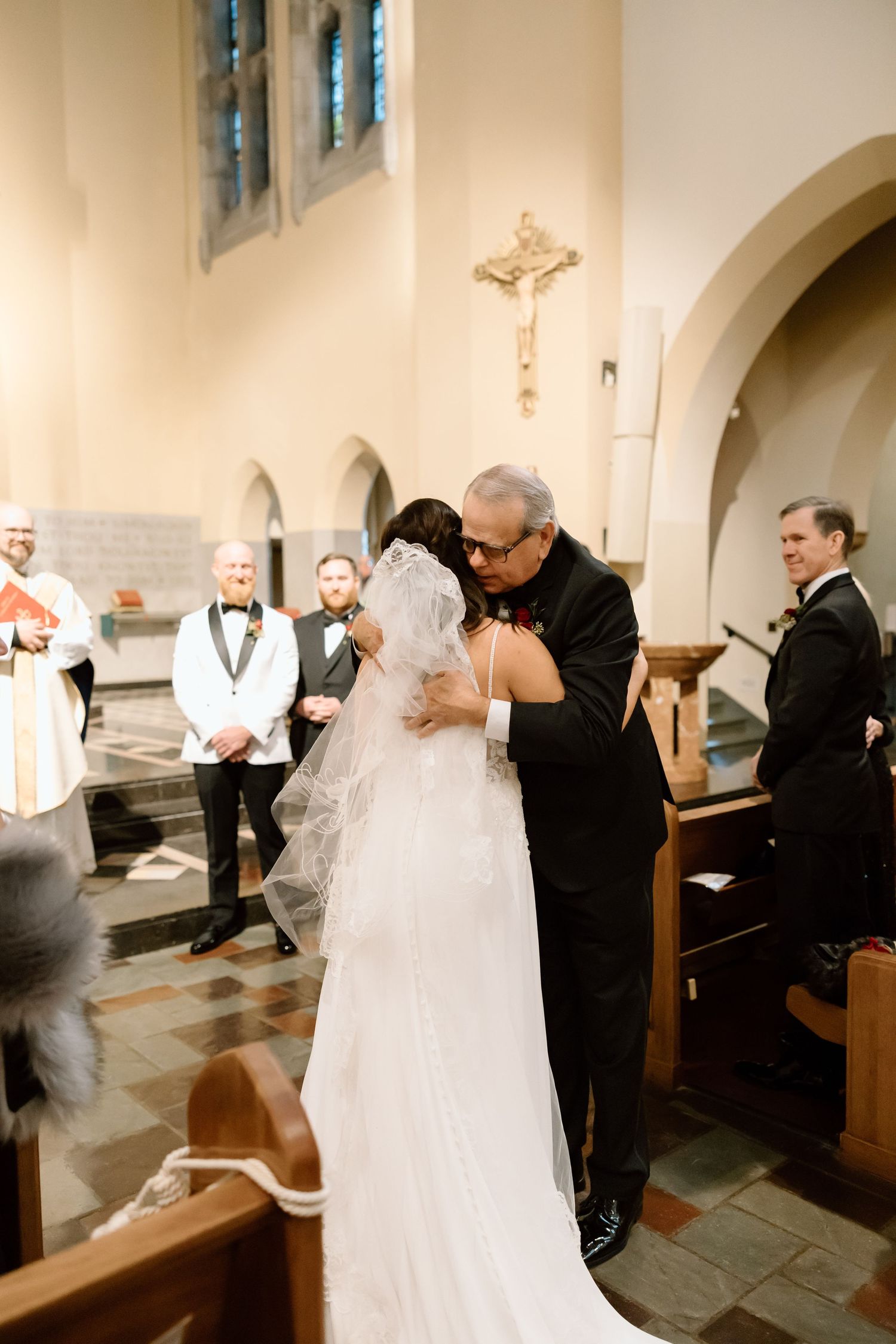 A tender moment during a wedding ceremony inside a traditional church with stone floors and arched architecture.