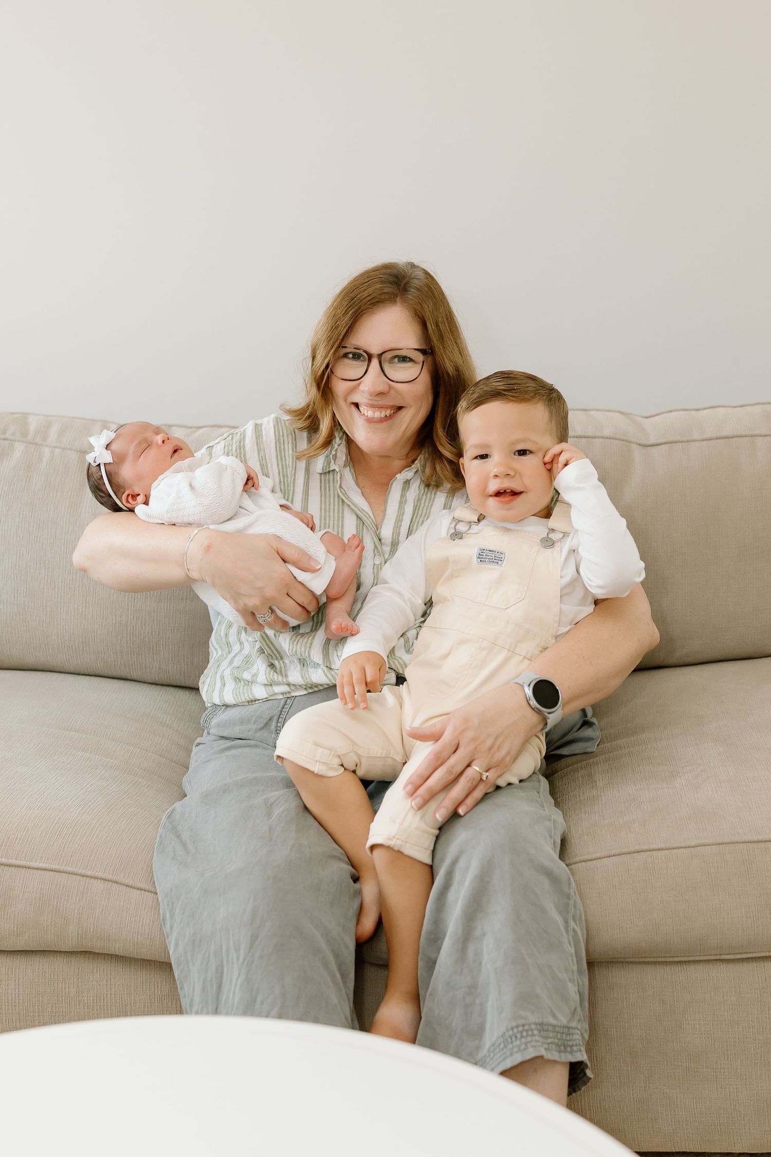 A series of candid photos showing a baby and adult sitting together on a light gray couch.