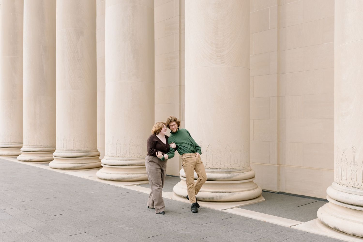 Architectural detail of white classical columns creating a repeating pattern against a light background.