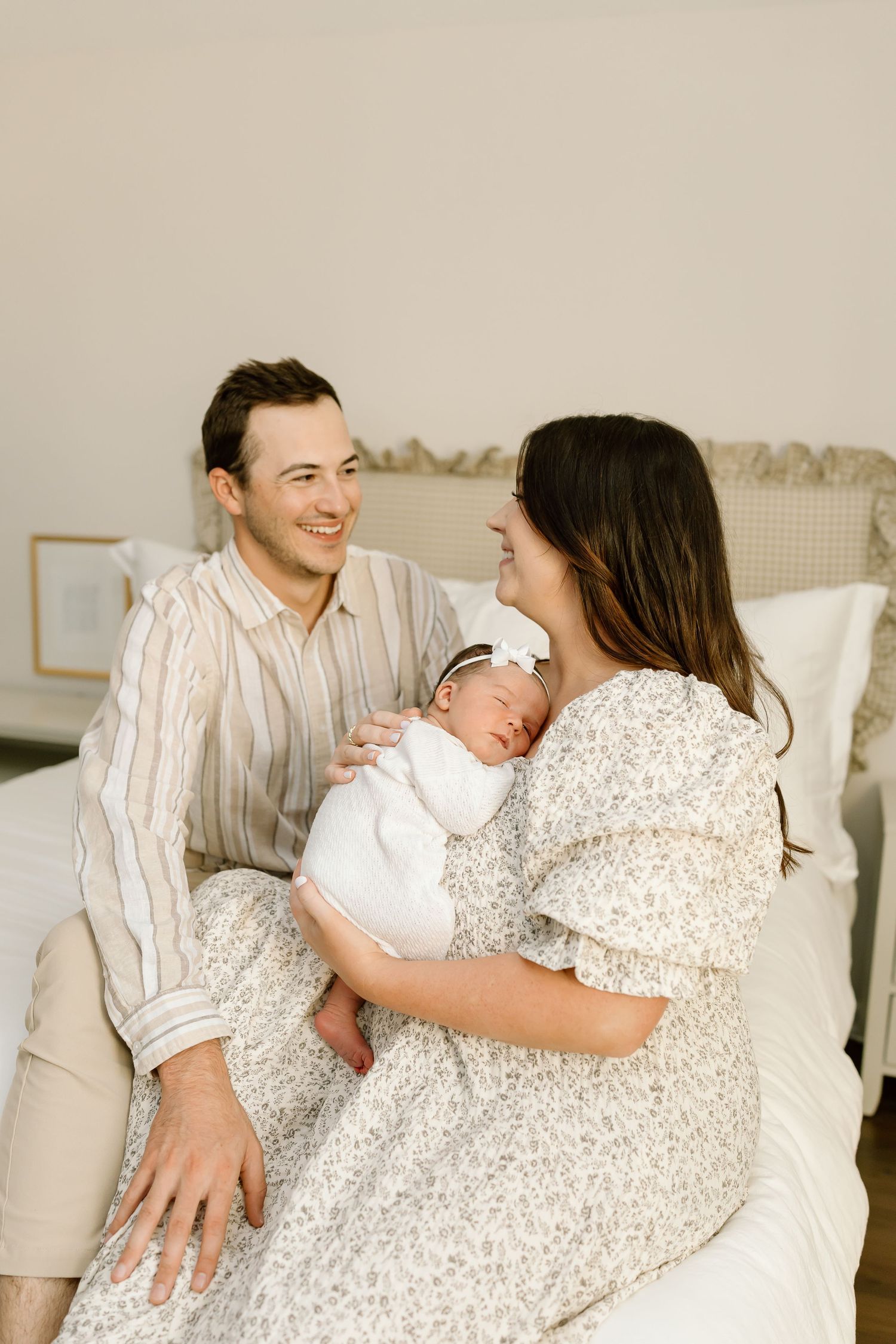 A family shares tender moments together in a series of intimate lifestyle photos on a light-colored couch.
