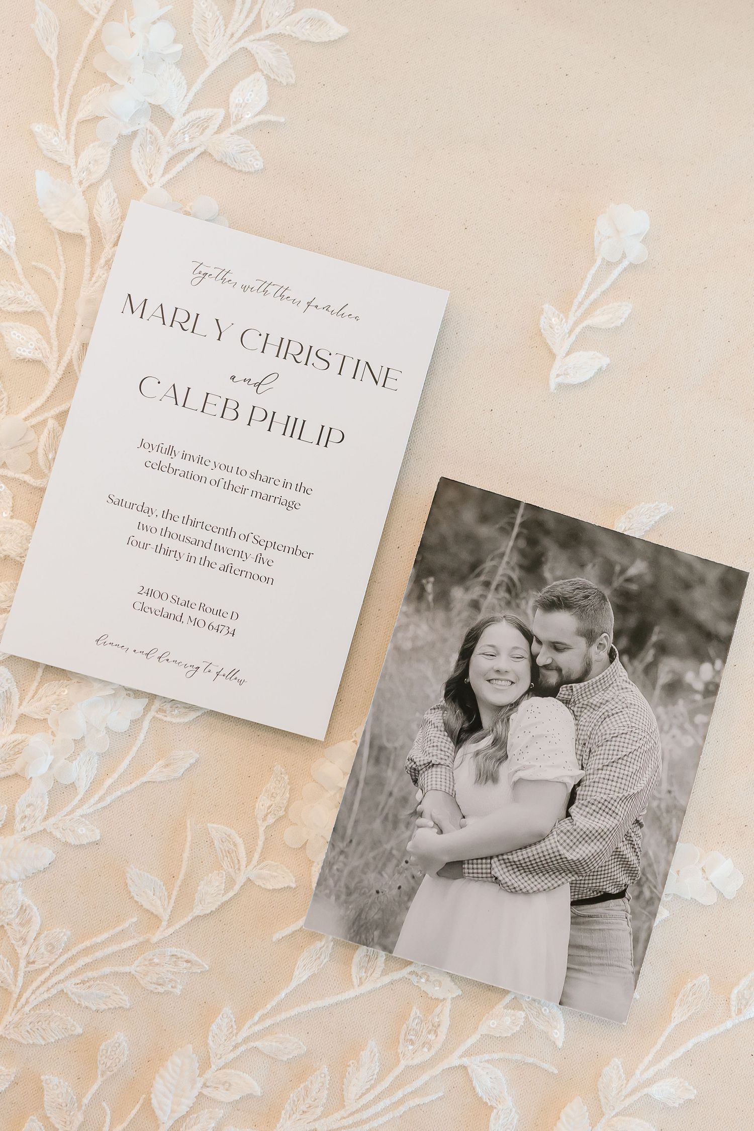 Wedding invitation and engagement photo displayed on a light beige floral background.