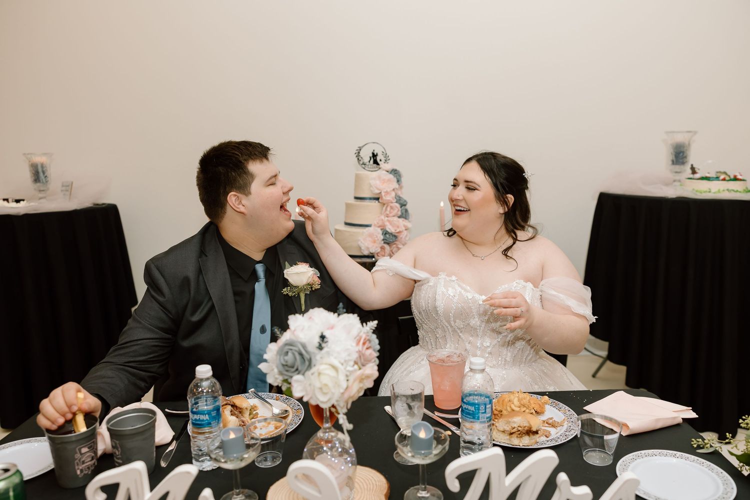 A couple shares a joyful moment while dining together at a restaurant table.