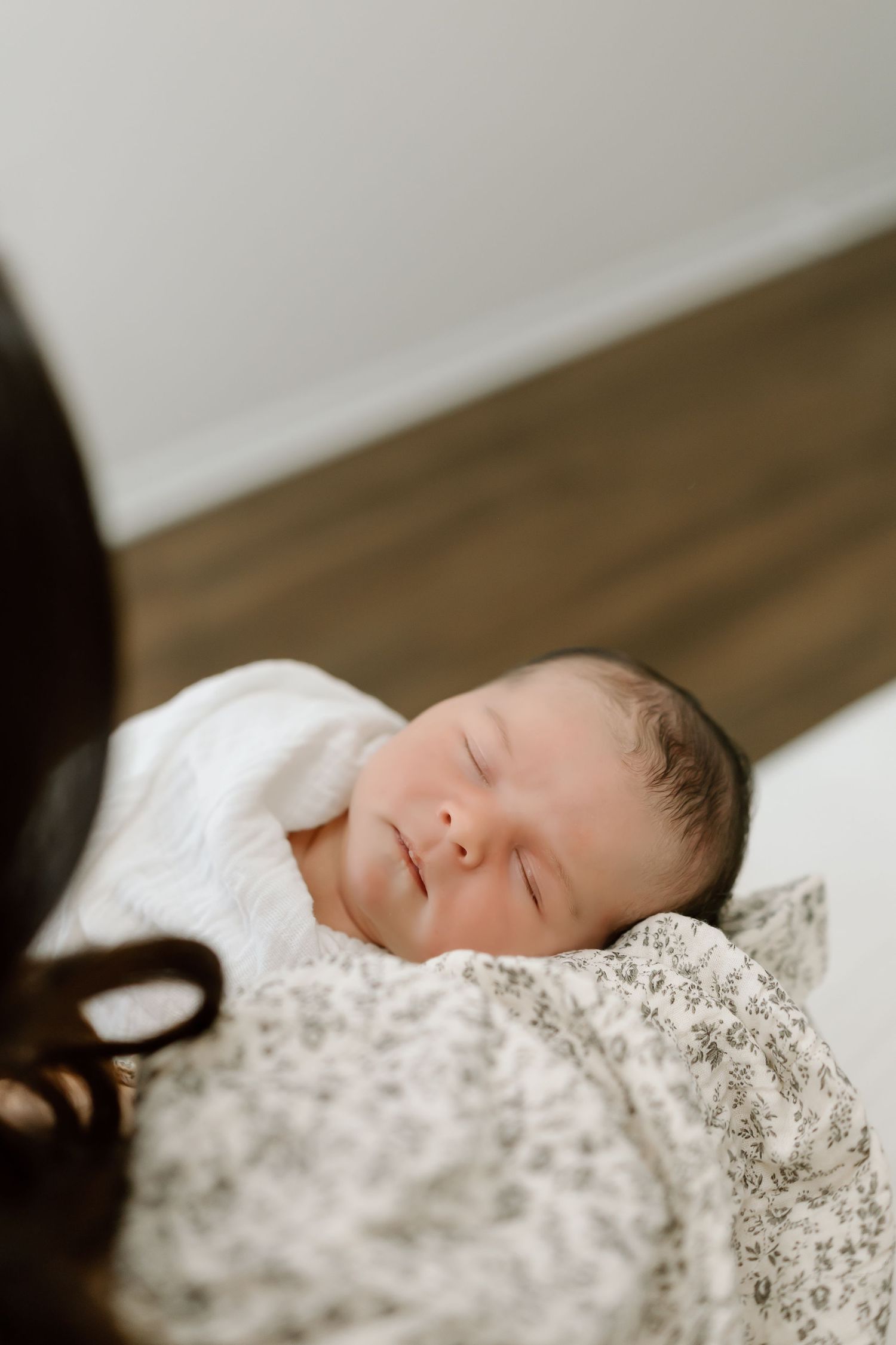 A sleeping baby rests peacefully on delicate white lace bedding in a serene portrait series.