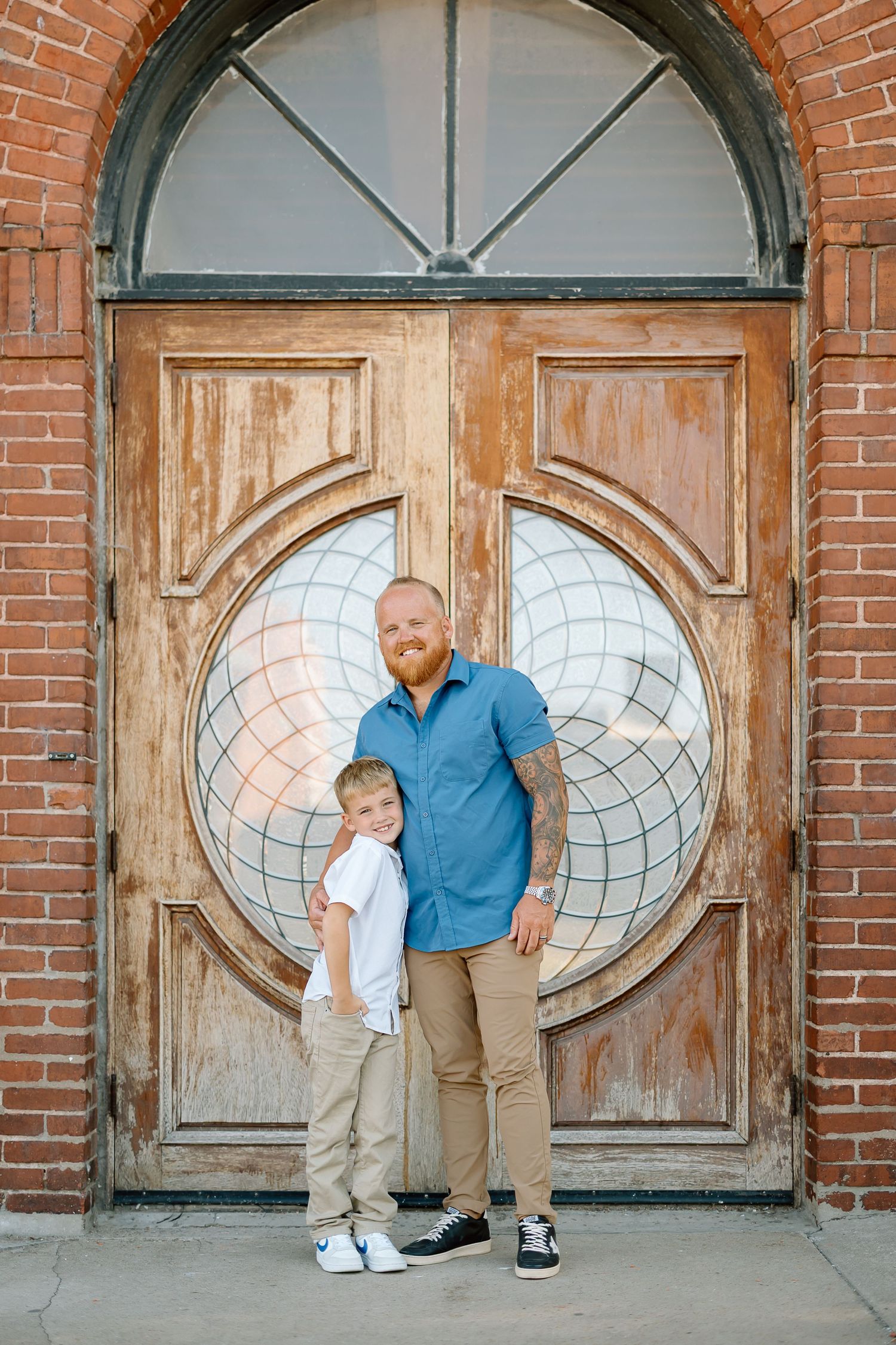 Creative photo series showing playful poses through vintage oval windows in a rustic brick wall.