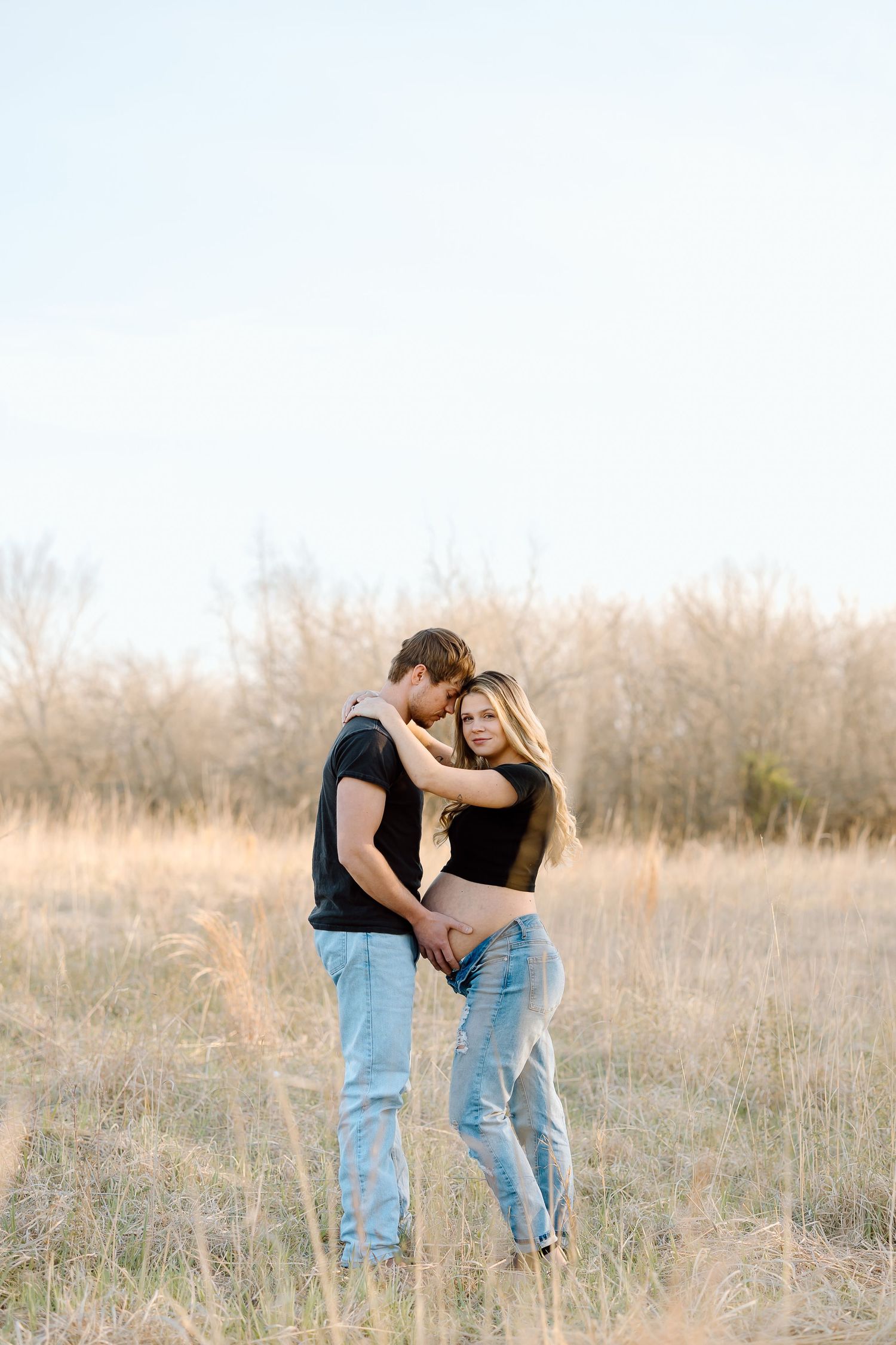 A couple shares intimate moments in a golden field during sunset, shown in three progressive poses.