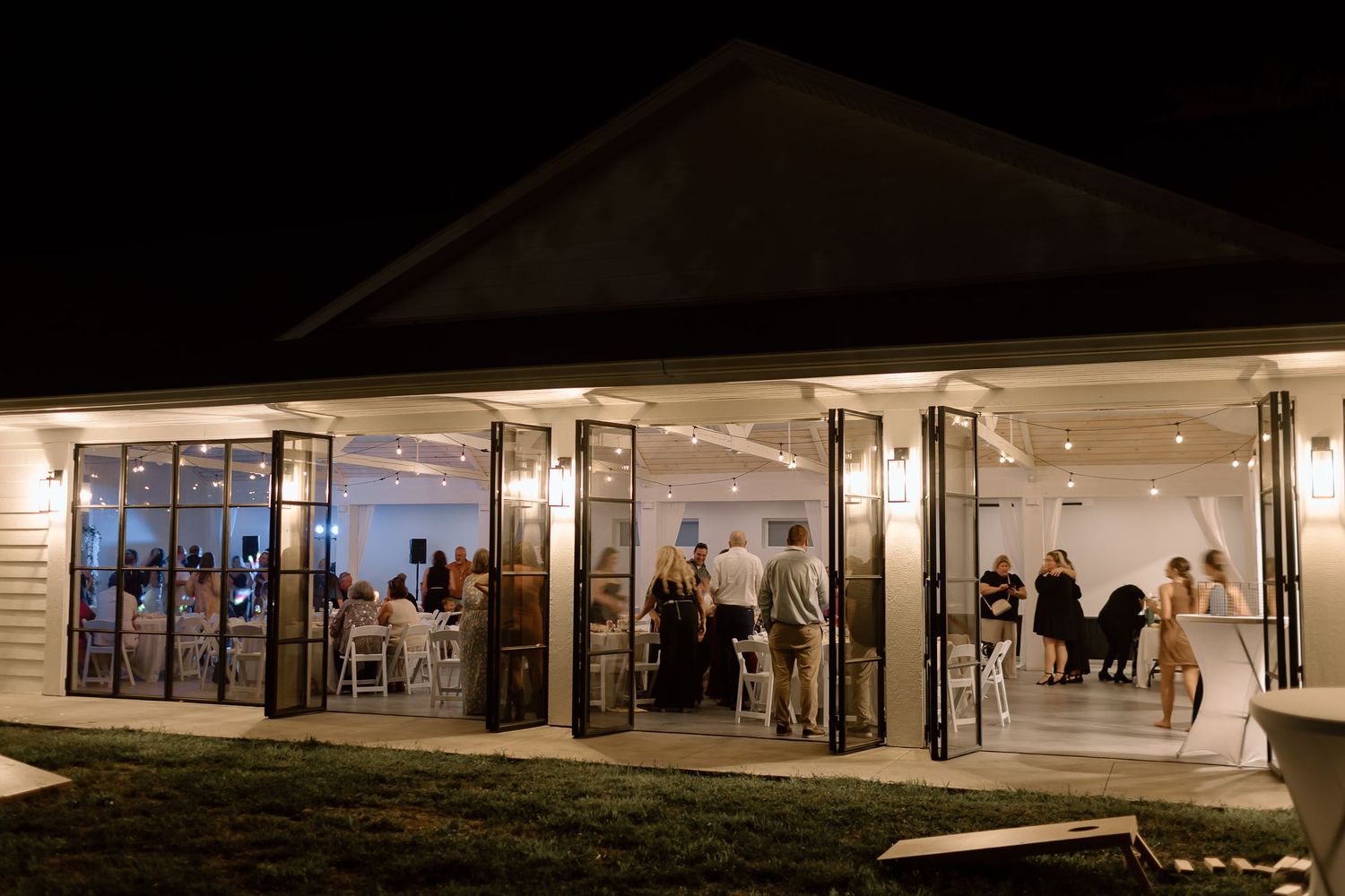 Modern retail storefront with large glass windows illuminated at night creating a warm inviting glow.
