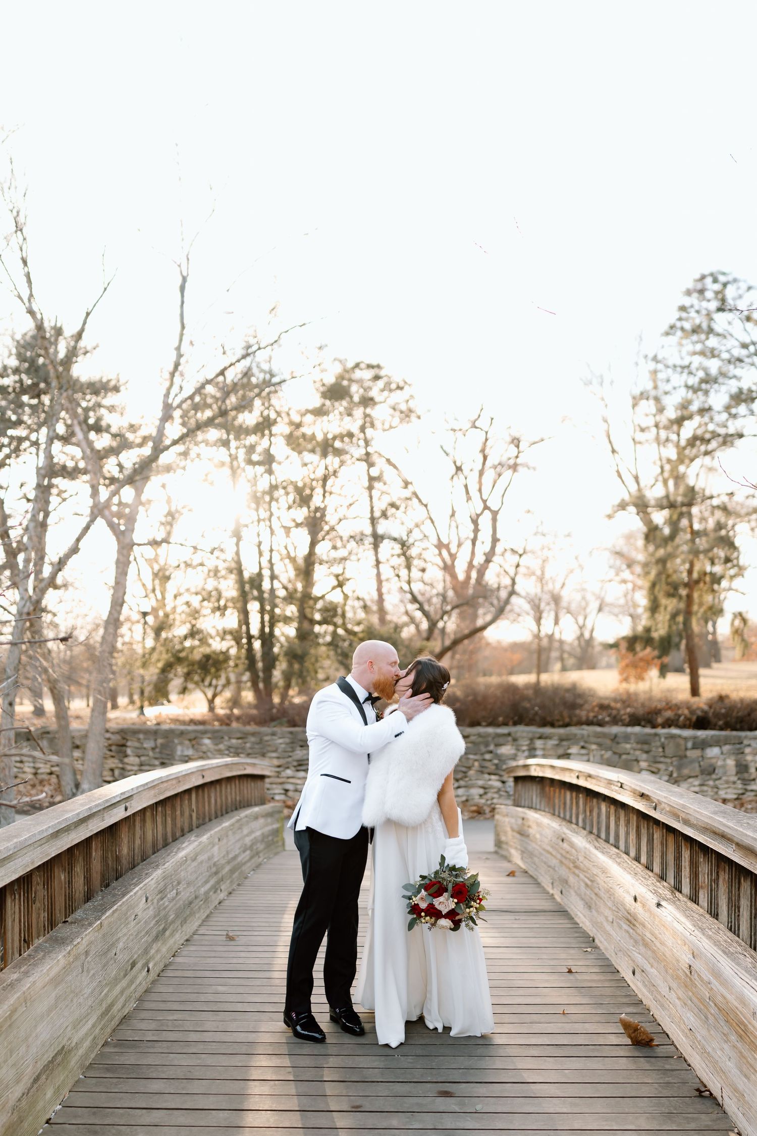 A romantic couple shares intimate moments on a wooden bridge during golden hour at sunset.