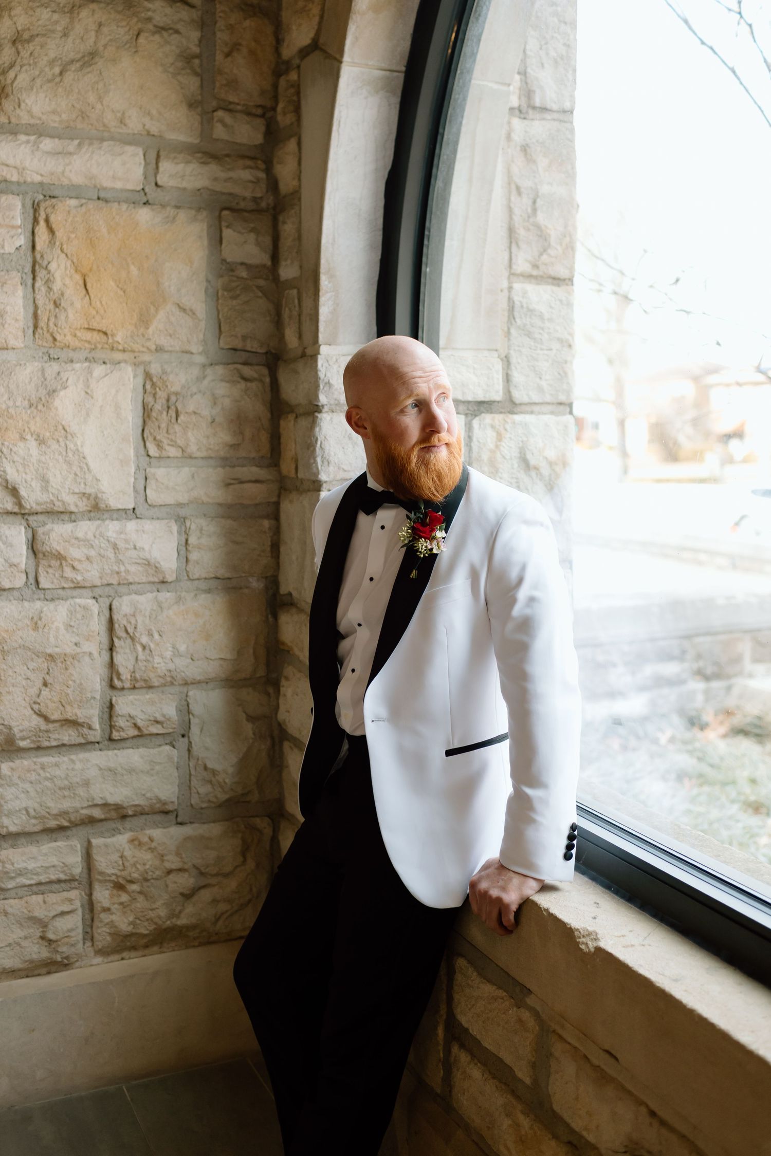 Three sequential photos of someone in formal attire gazing thoughtfully out of a stone-framed window.